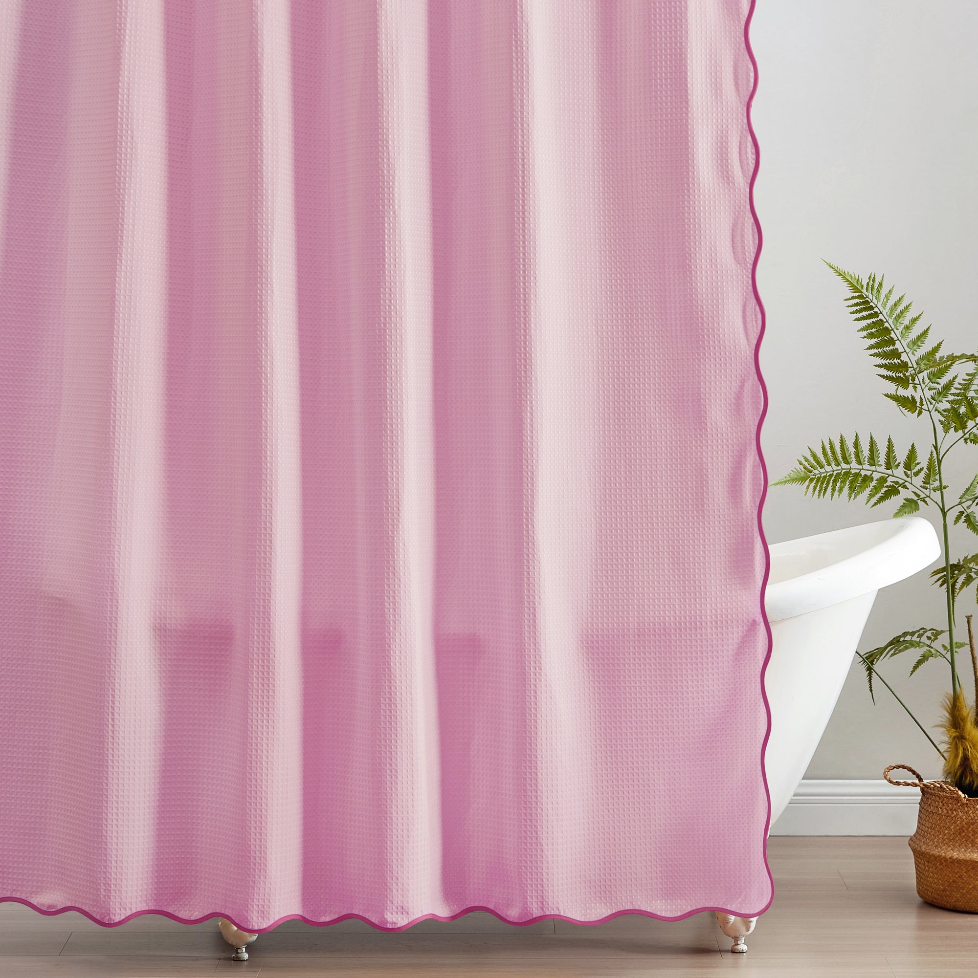 Pink scalloped curtain with a plant in the corner