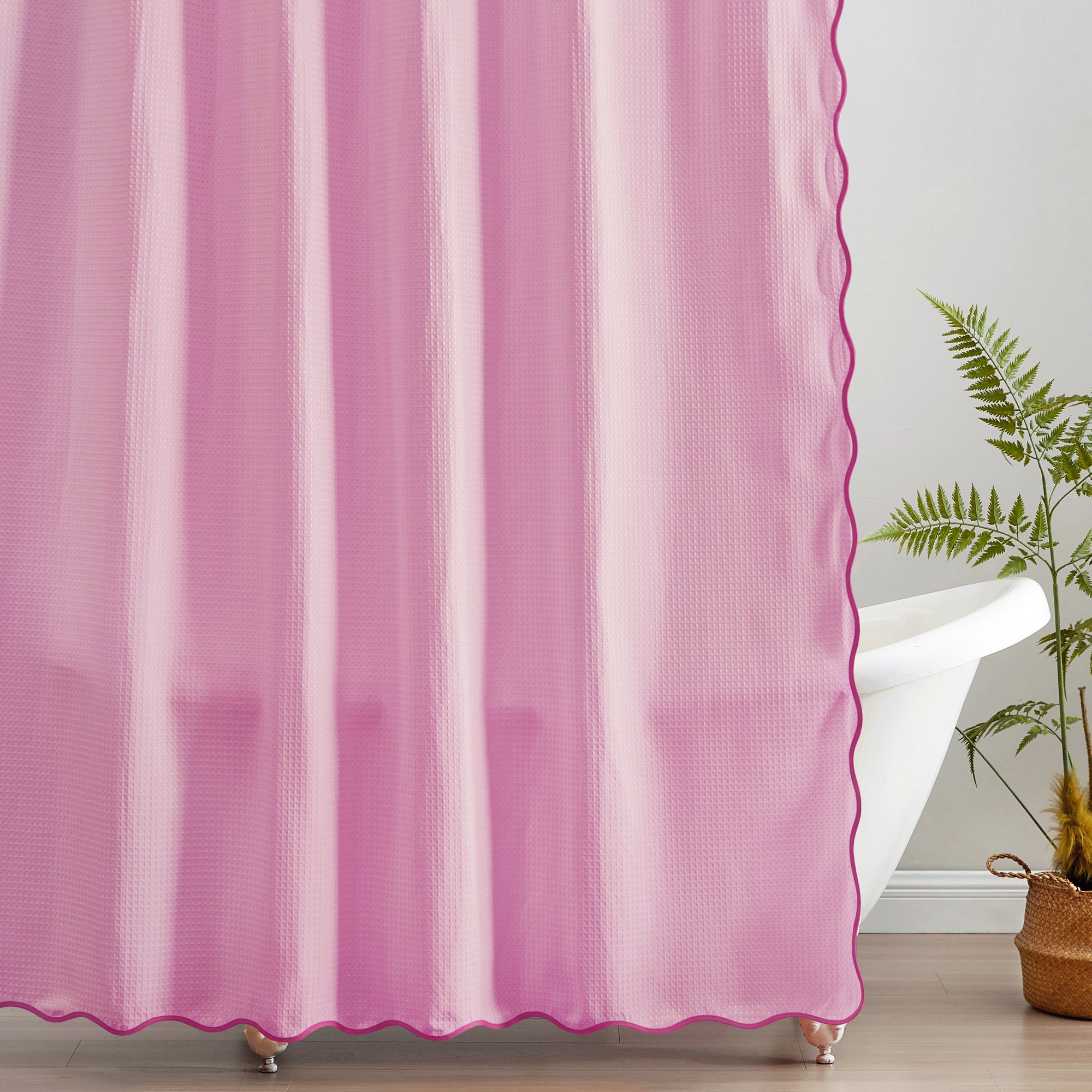 Pink scalloped curtain with a plant in the corner