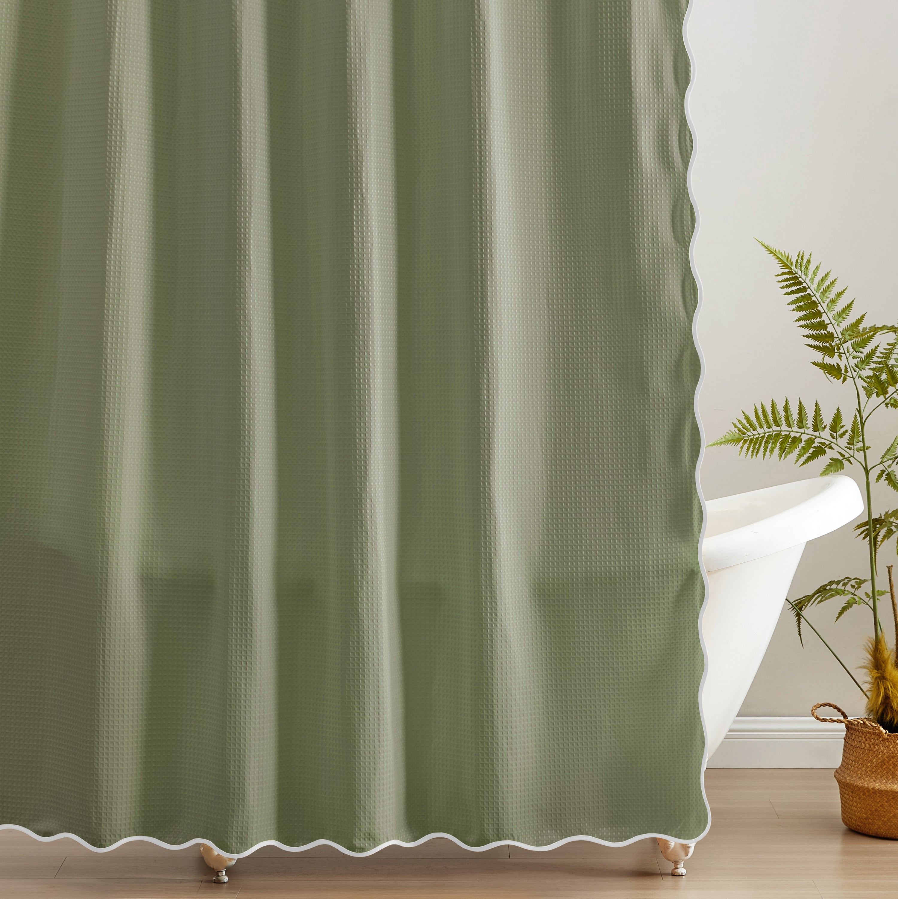 Green curtain with white trim in a room with a plant