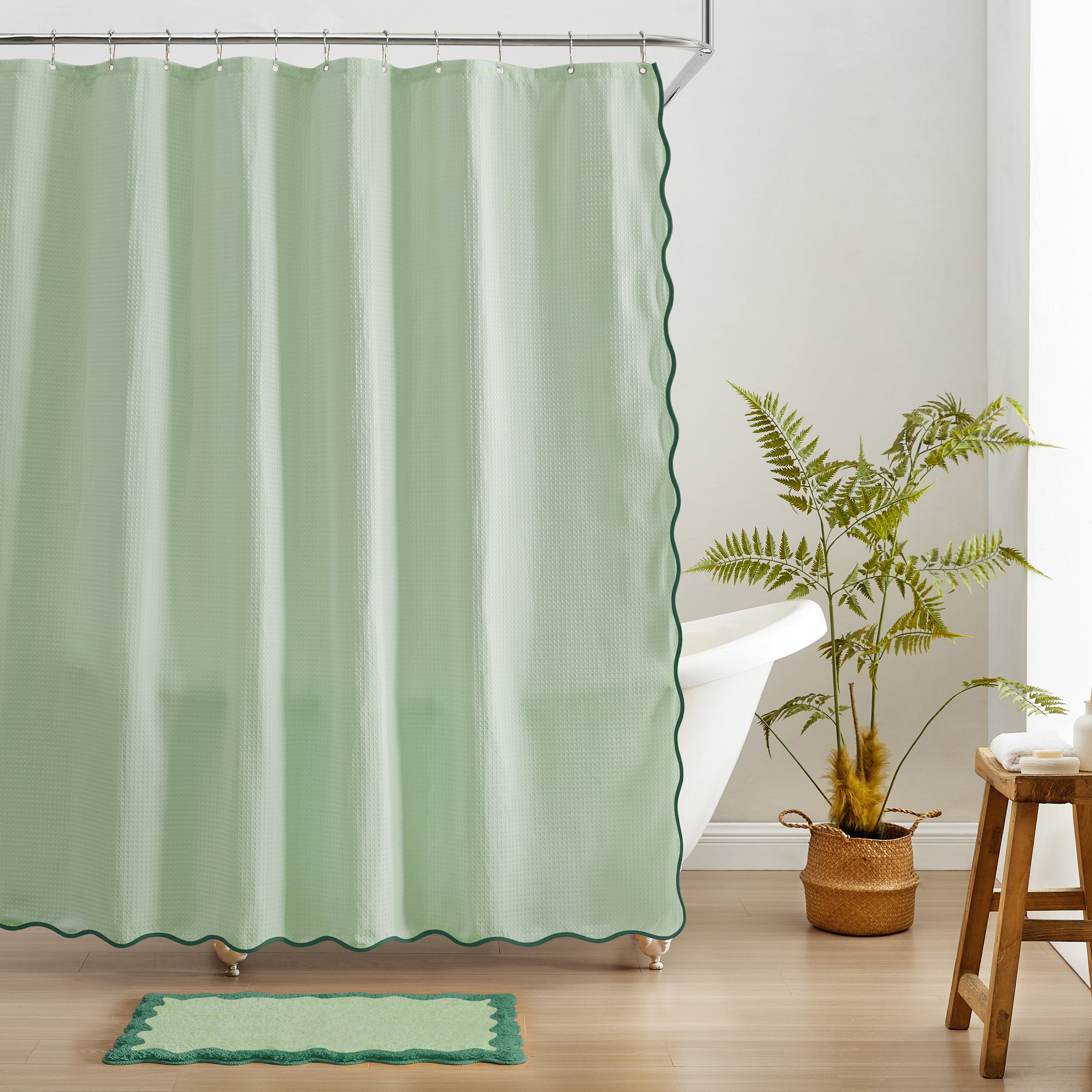 Green shower curtain with scalloped edge in a bathroom setting.