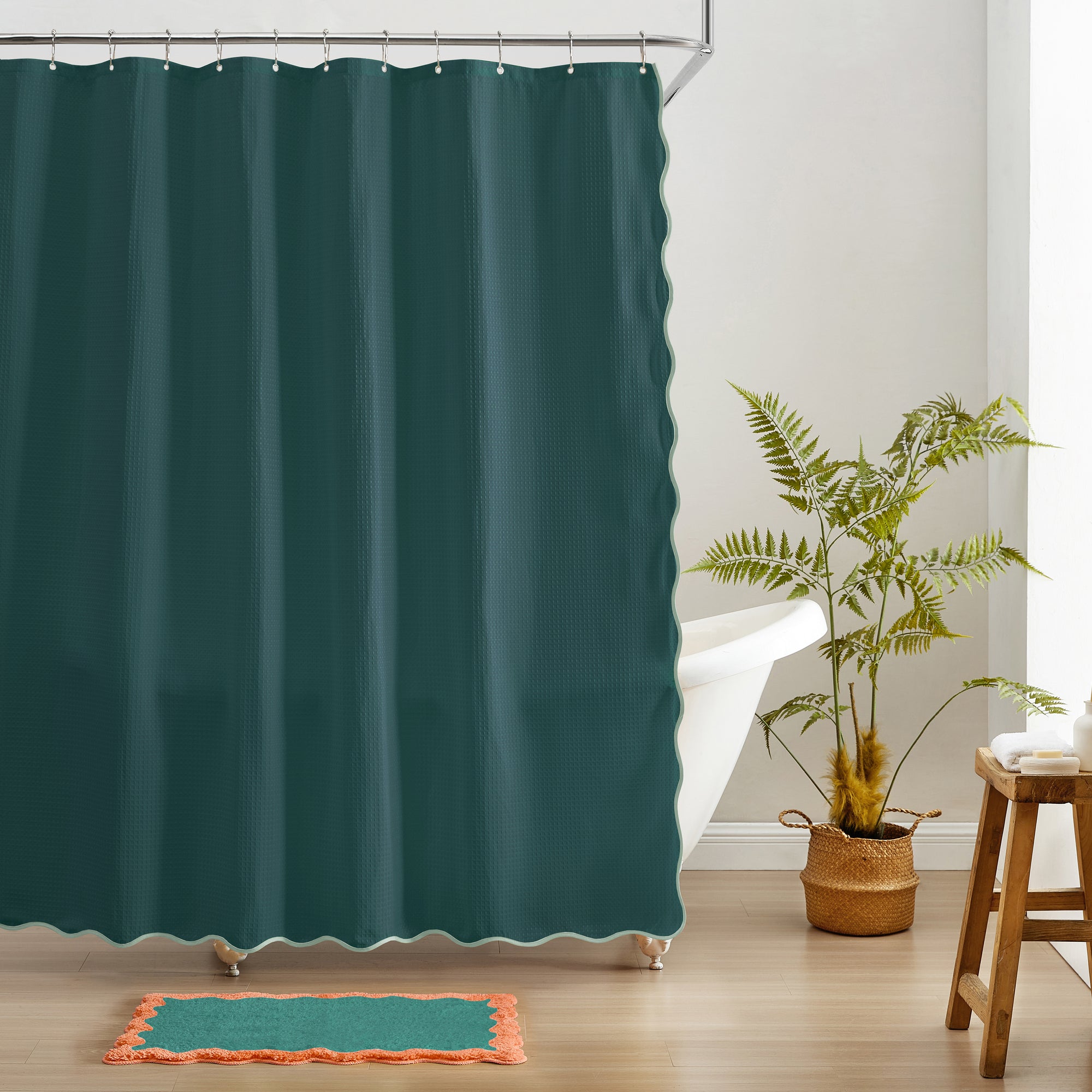 Teal shower curtain in a bathroom with a plant and wooden stool.
