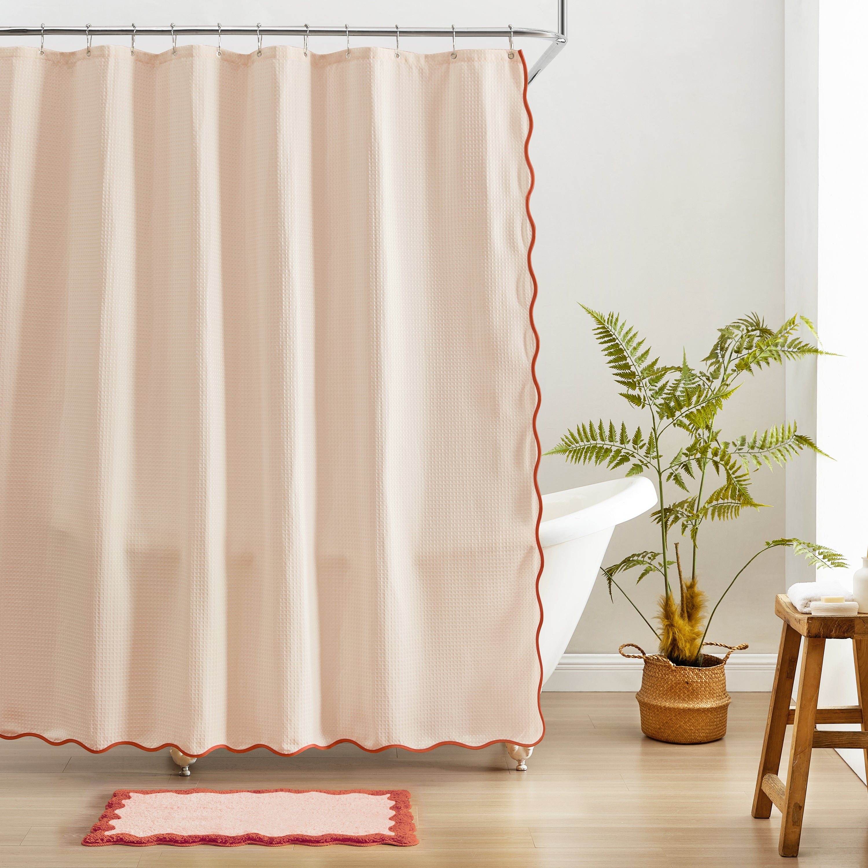Beige shower curtain with red trim in a bathroom setting.