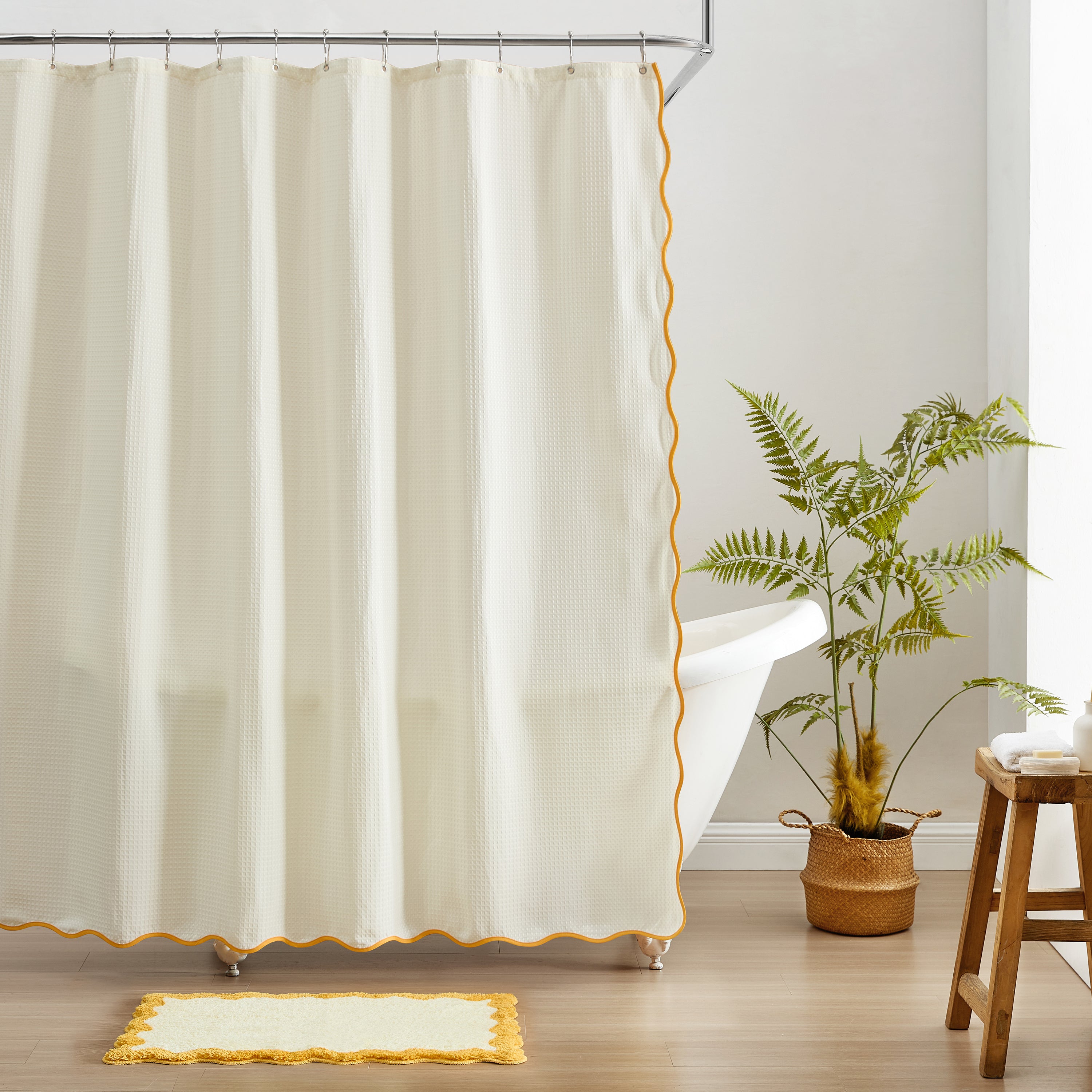 Beige shower curtain with gold trim in a bathroom setting.