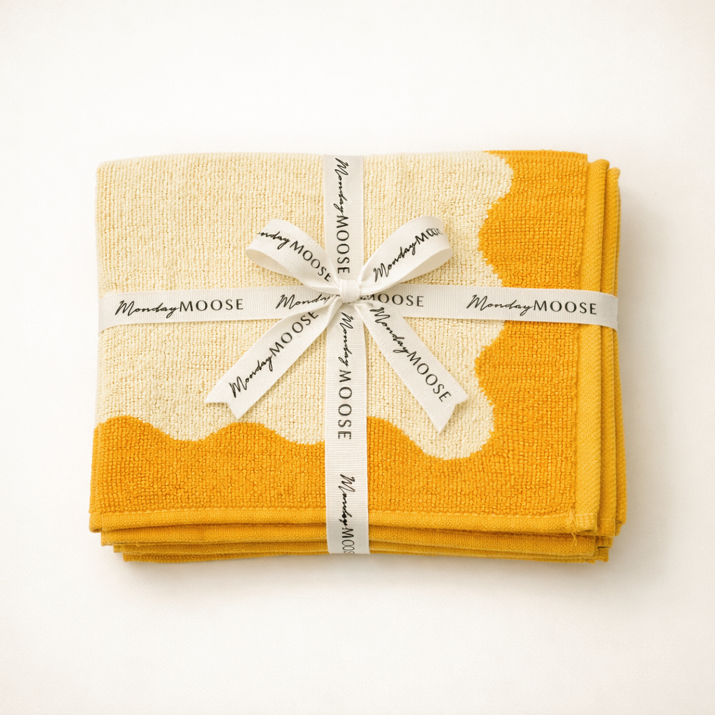 Set of yellow and beige napkins tied with a white ribbon on a white background