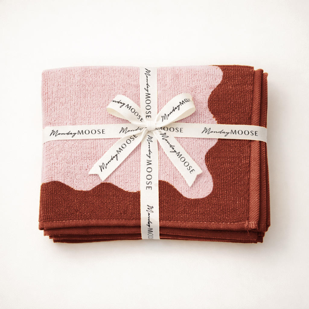 Folded pink and brown fabric with a white ribbon and 'Monday Moose' label on a white background
