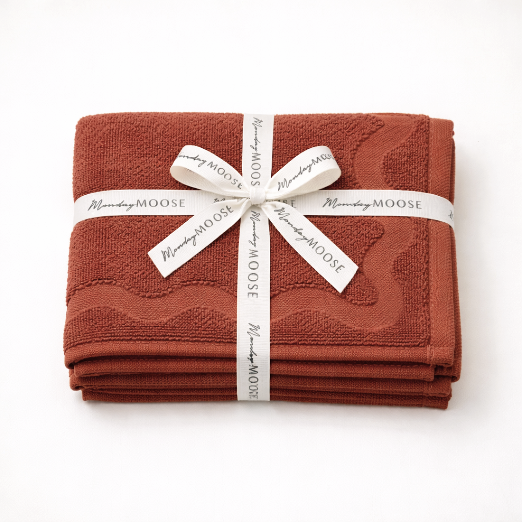 Stack of brown towels tied with a ribbon on a white background