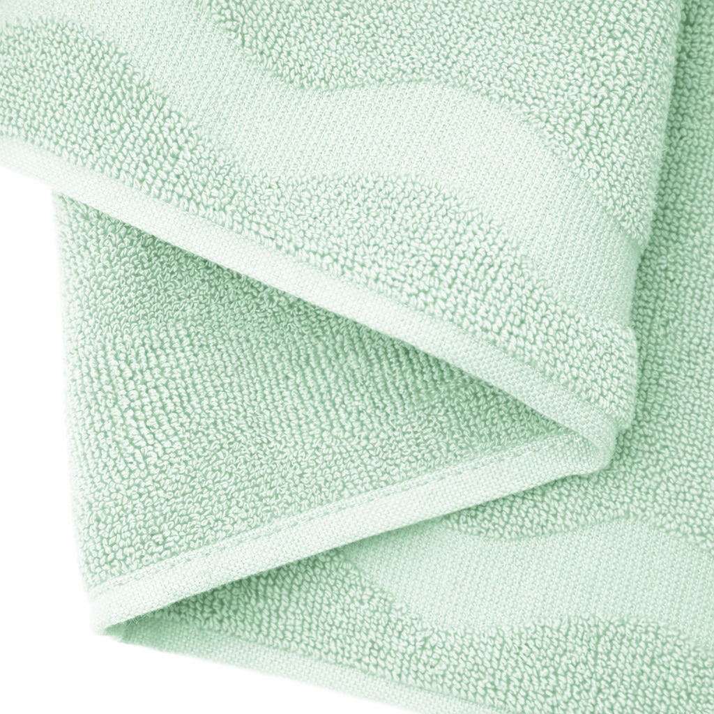 Folded light green towel on a white background