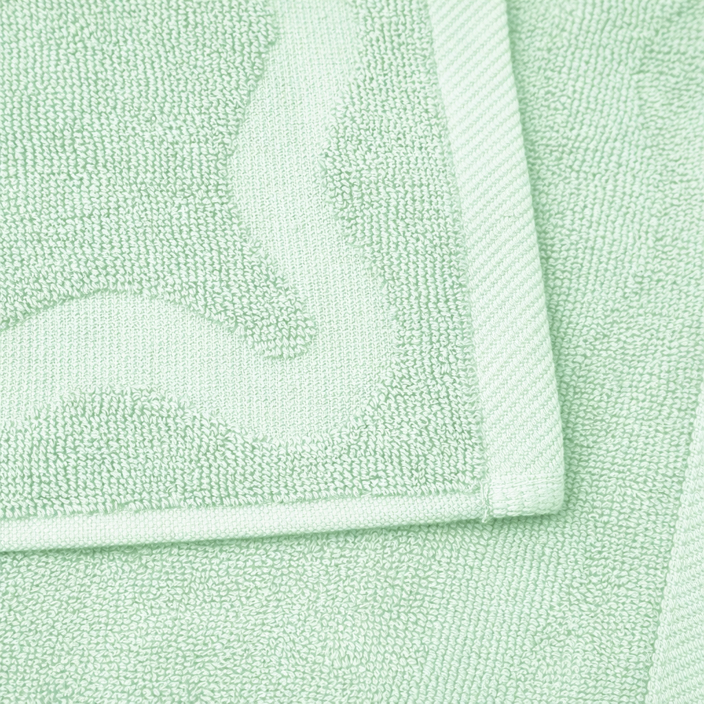 Close-up of a light green towel with folded corner