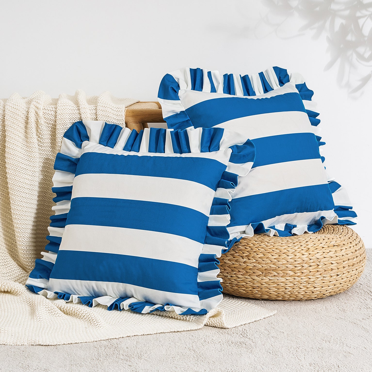 Blue and white striped pillows with ruffles on a neutral background