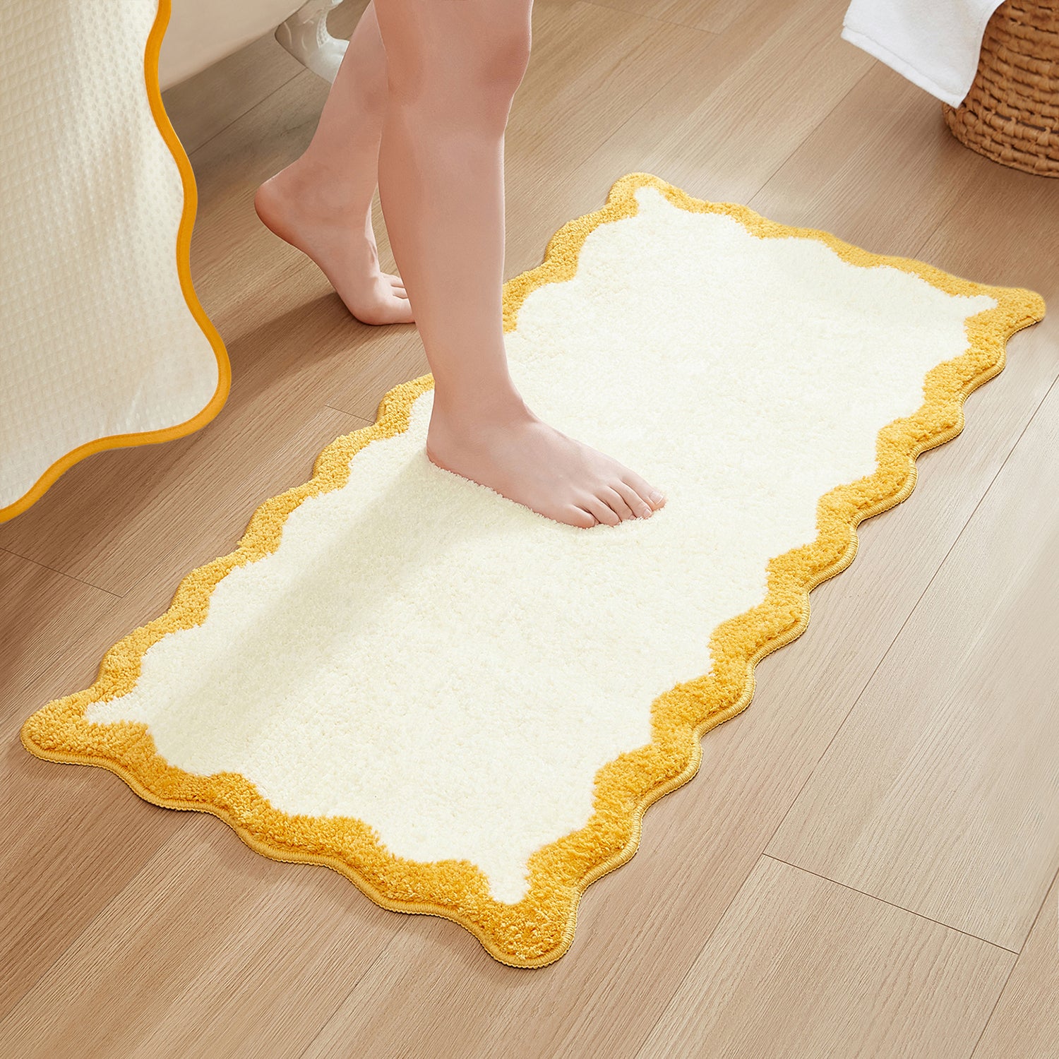 White bath mat with yellow border on a wooden floor, person stepping onto it.