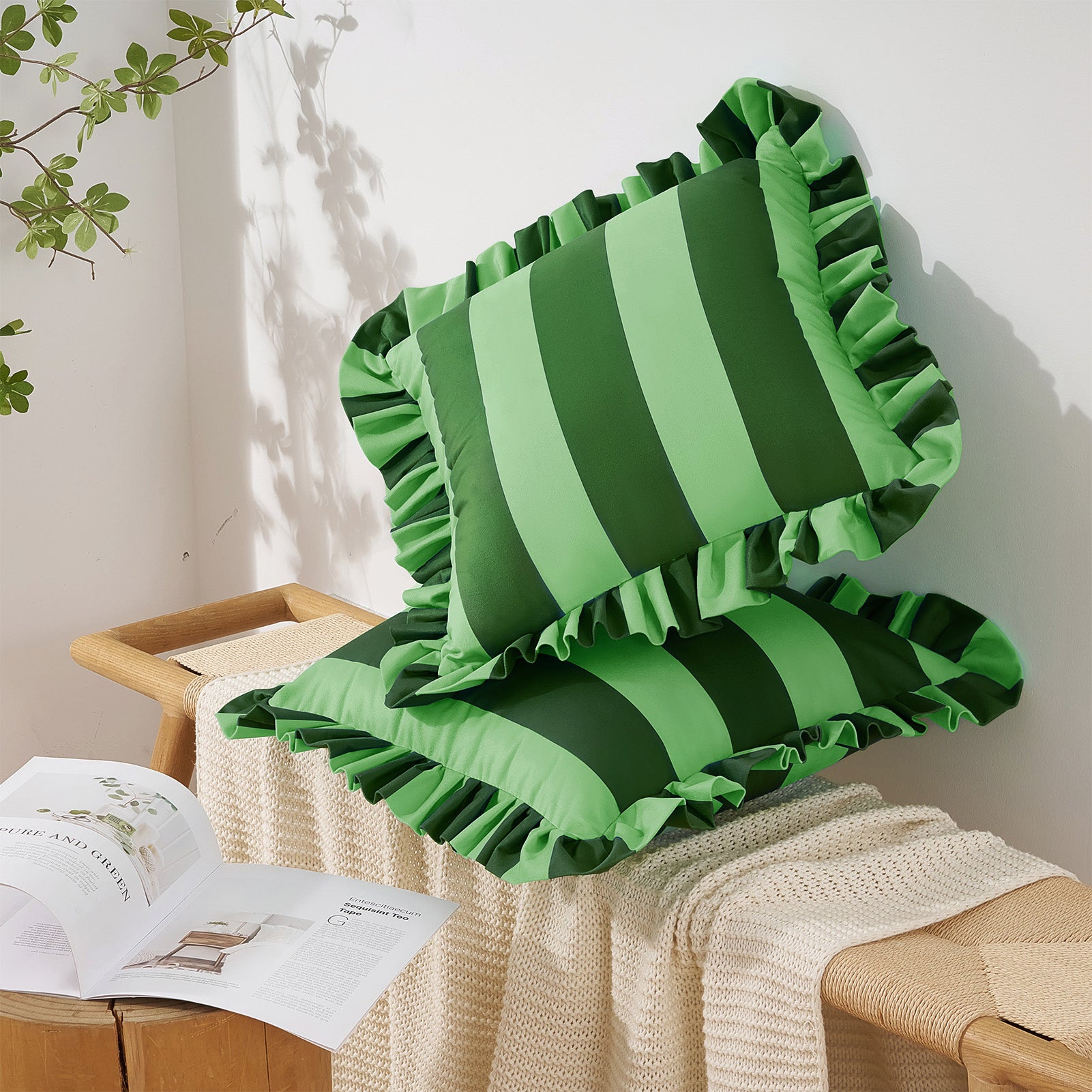 Green striped pillow with ruffled edges on a wooden stool against a white wall.