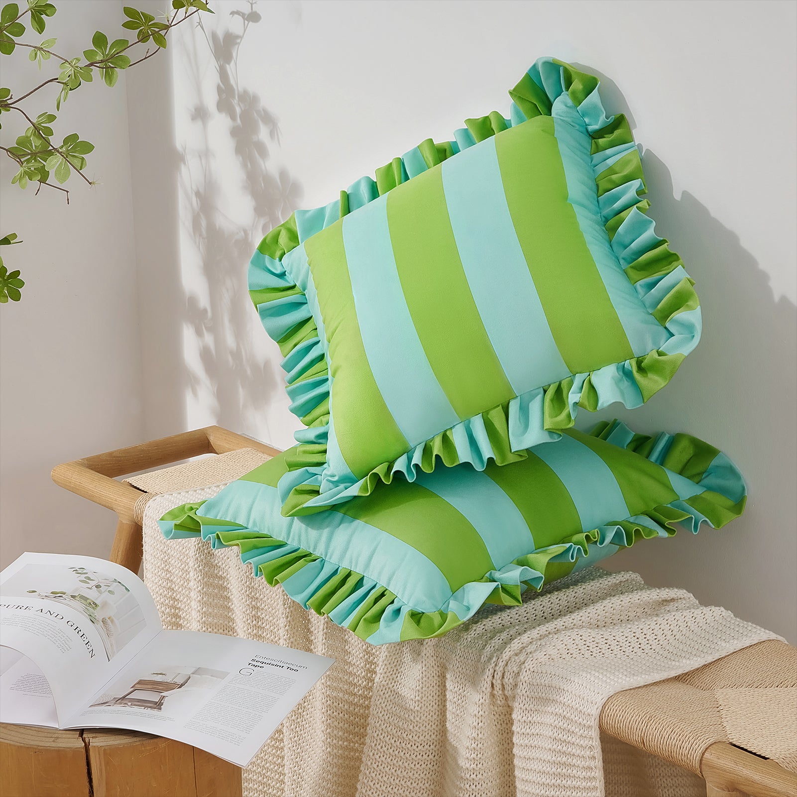 Green and blue striped pillows with ruffled edges on a wooden surface.