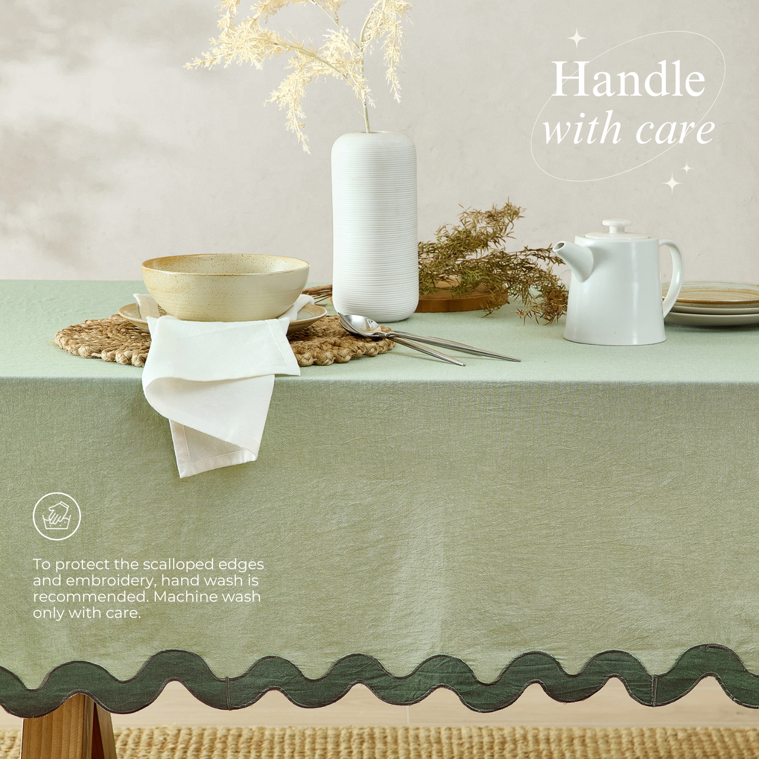 Table setting with a green tablecloth, white teapot, and decorative elements on a neutral background.