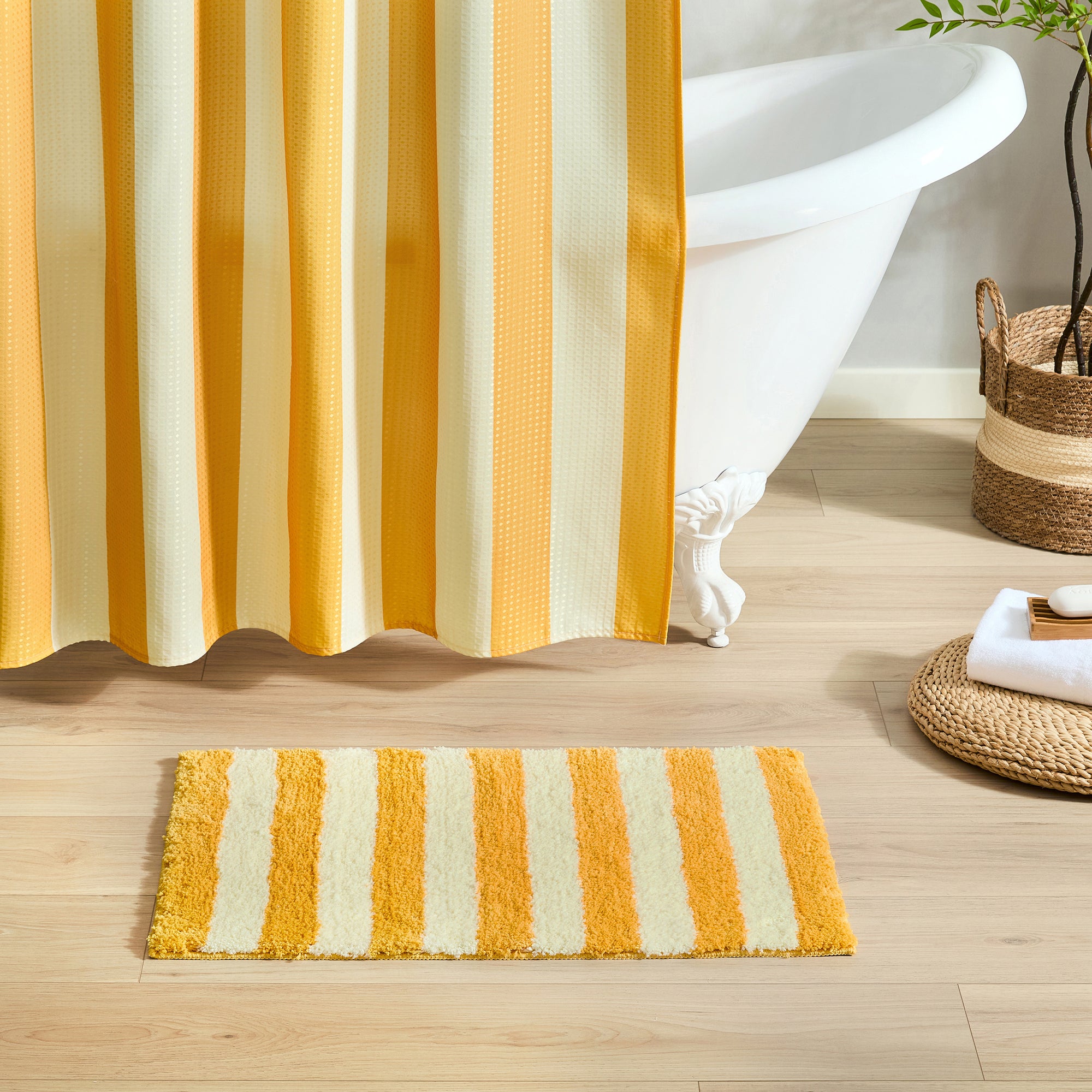 Striped shower curtain and bath mat in a bathroom setting