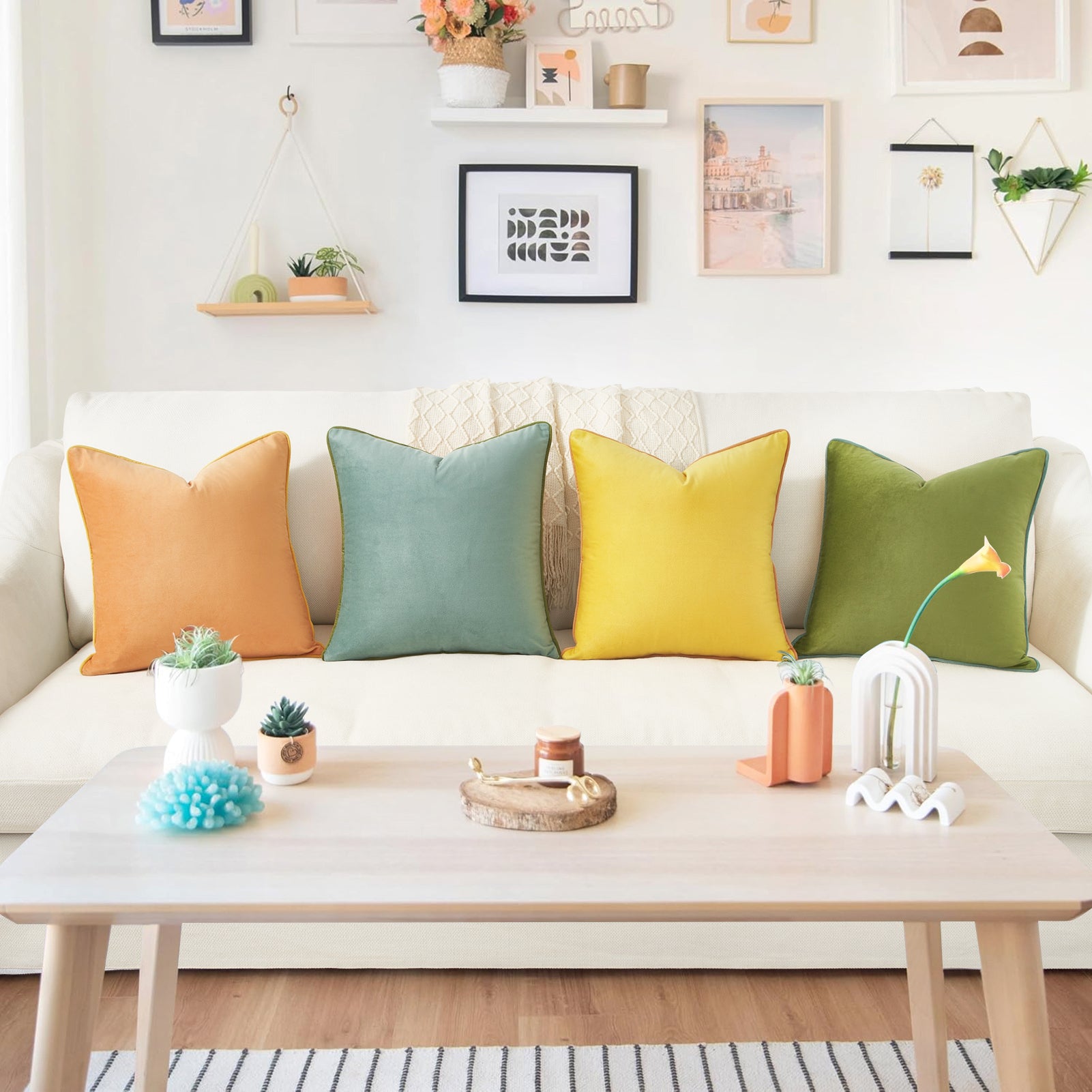 Living room with a white sofa adorned with colorful pillows, a wooden coffee table with decorative items, and framed pictures on the wall.