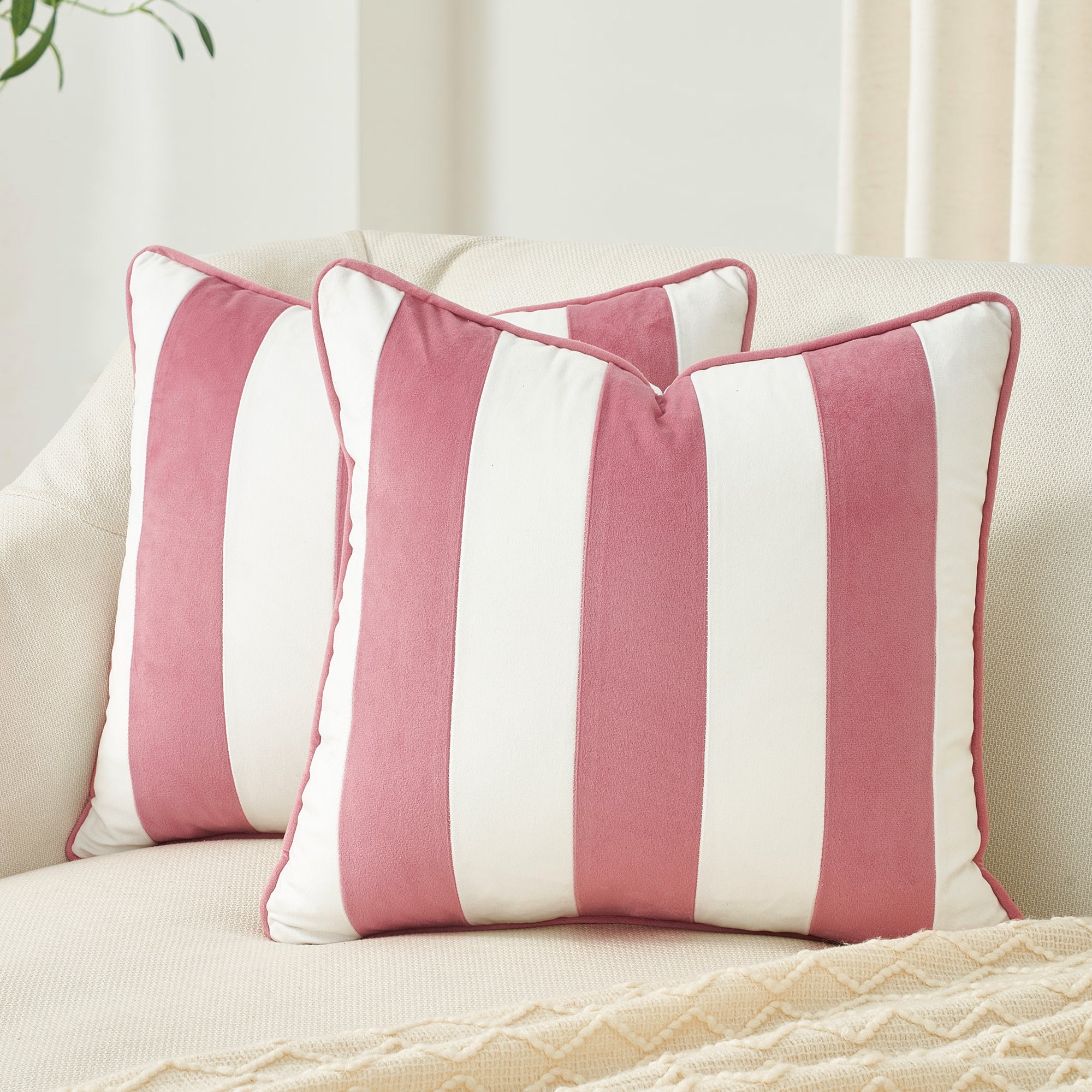 Pink and white striped pillows on a beige sofa