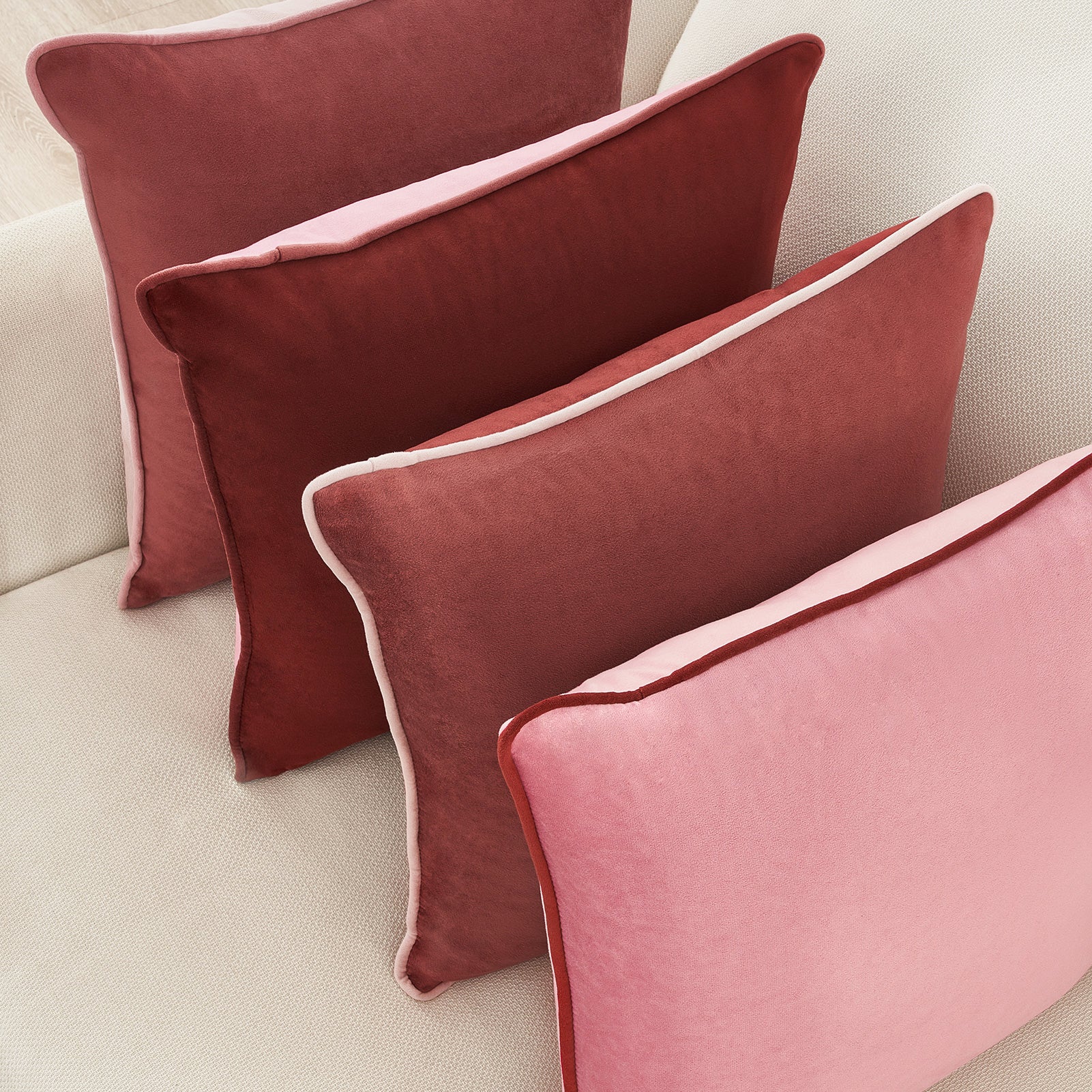 Pink cushions on a beige sofa