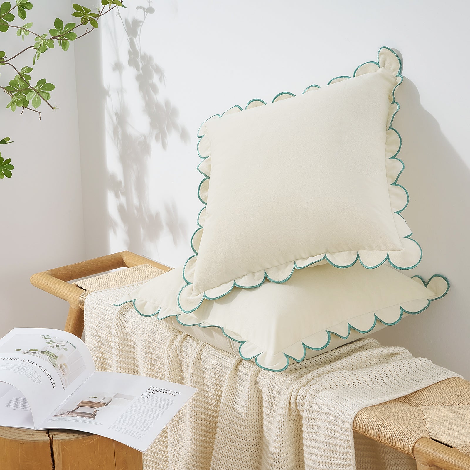 Decorative pillow with scalloped edge on a wooden stool against a white wall.
