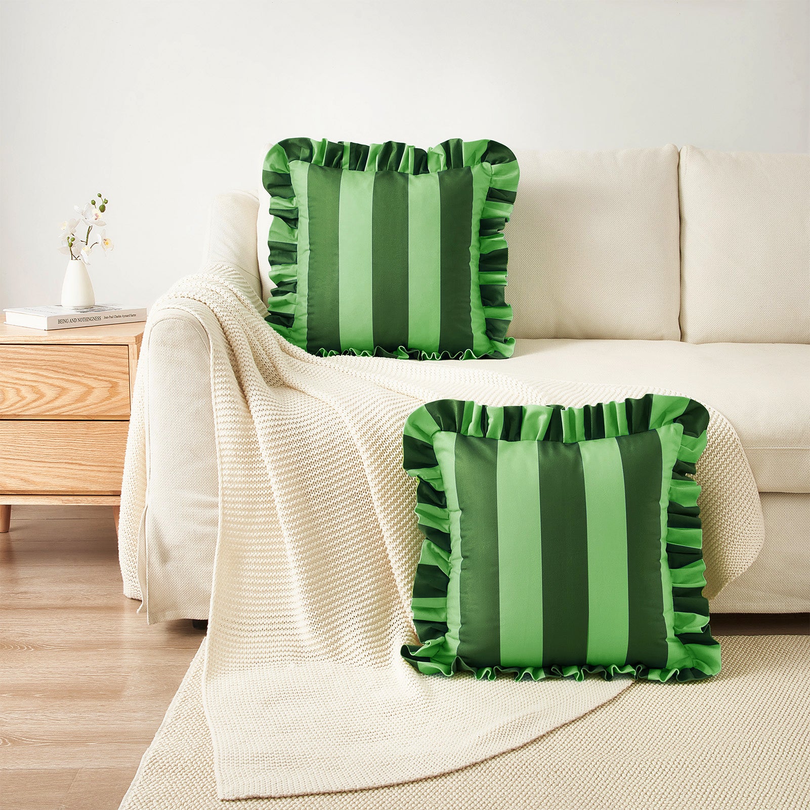 Green striped pillows on a beige sofa in a living room setting.