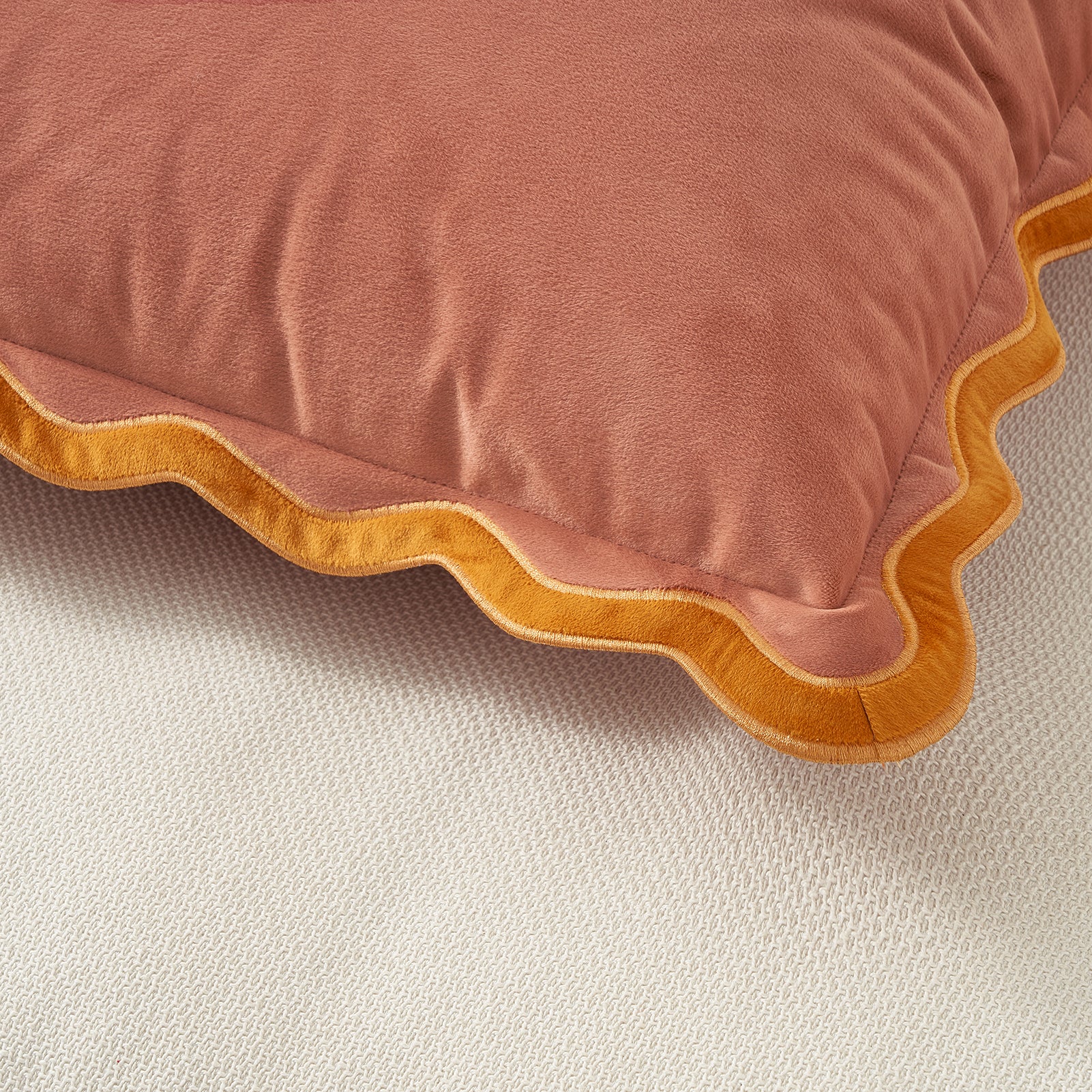 Pink pillow with wavy yellow edge on a beige background
