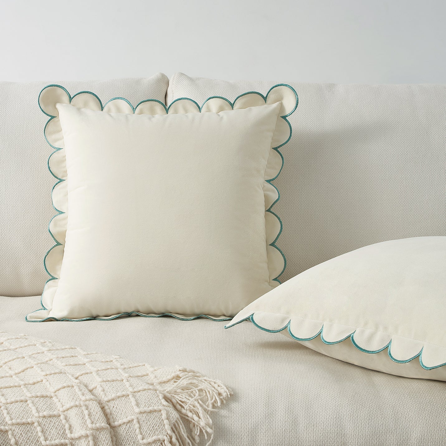 White pillows with scalloped edges on a beige sofa