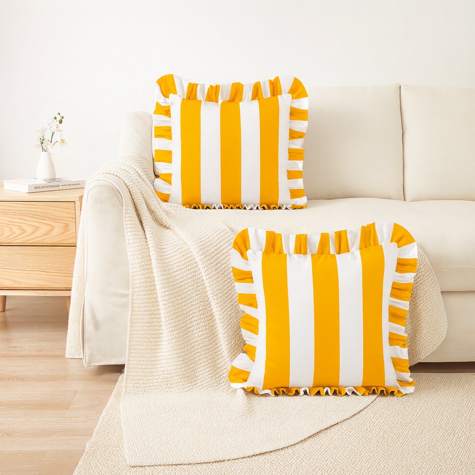 Yellow and white striped pillows on a beige sofa in a living room setting.
