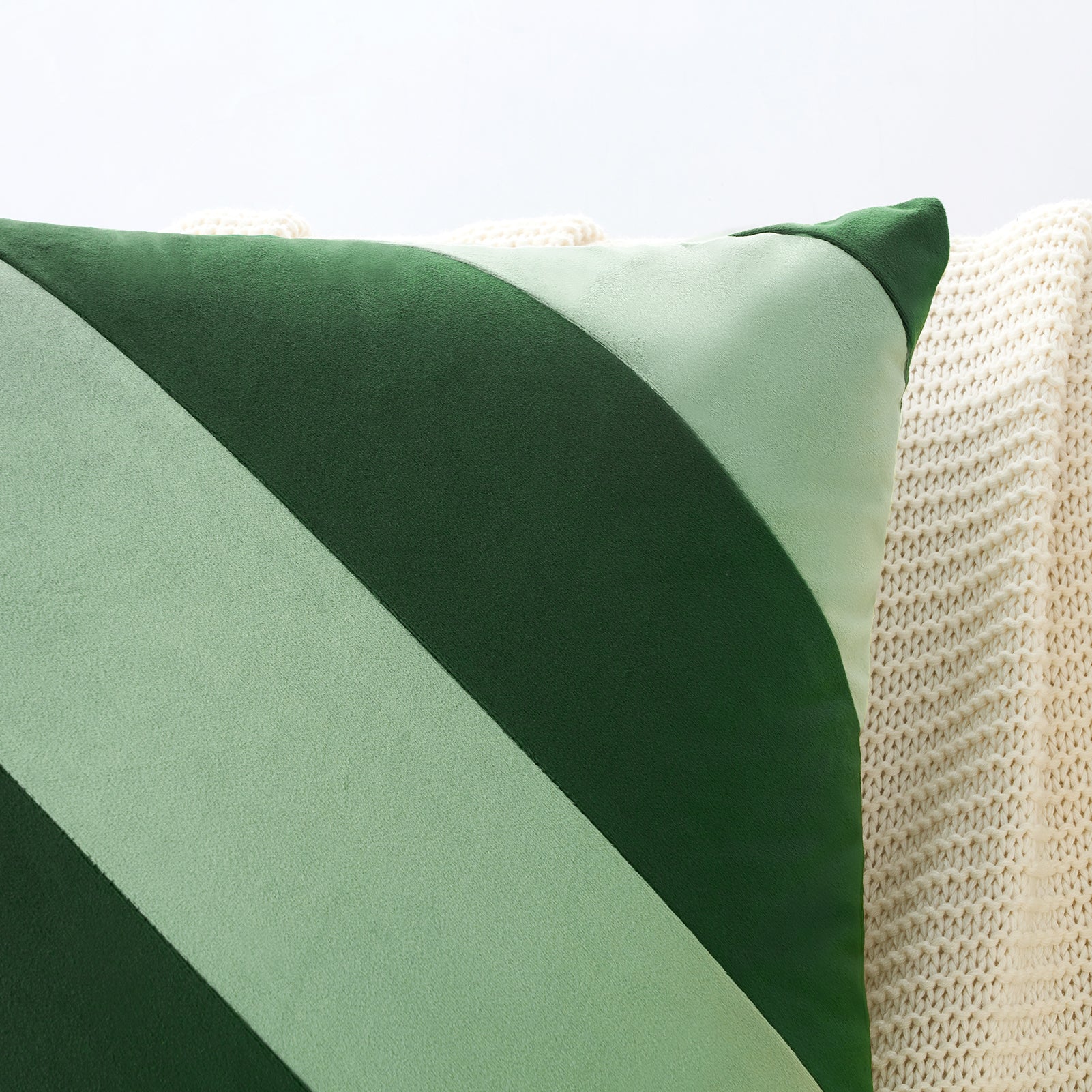 Green and beige pillow on a textured surface