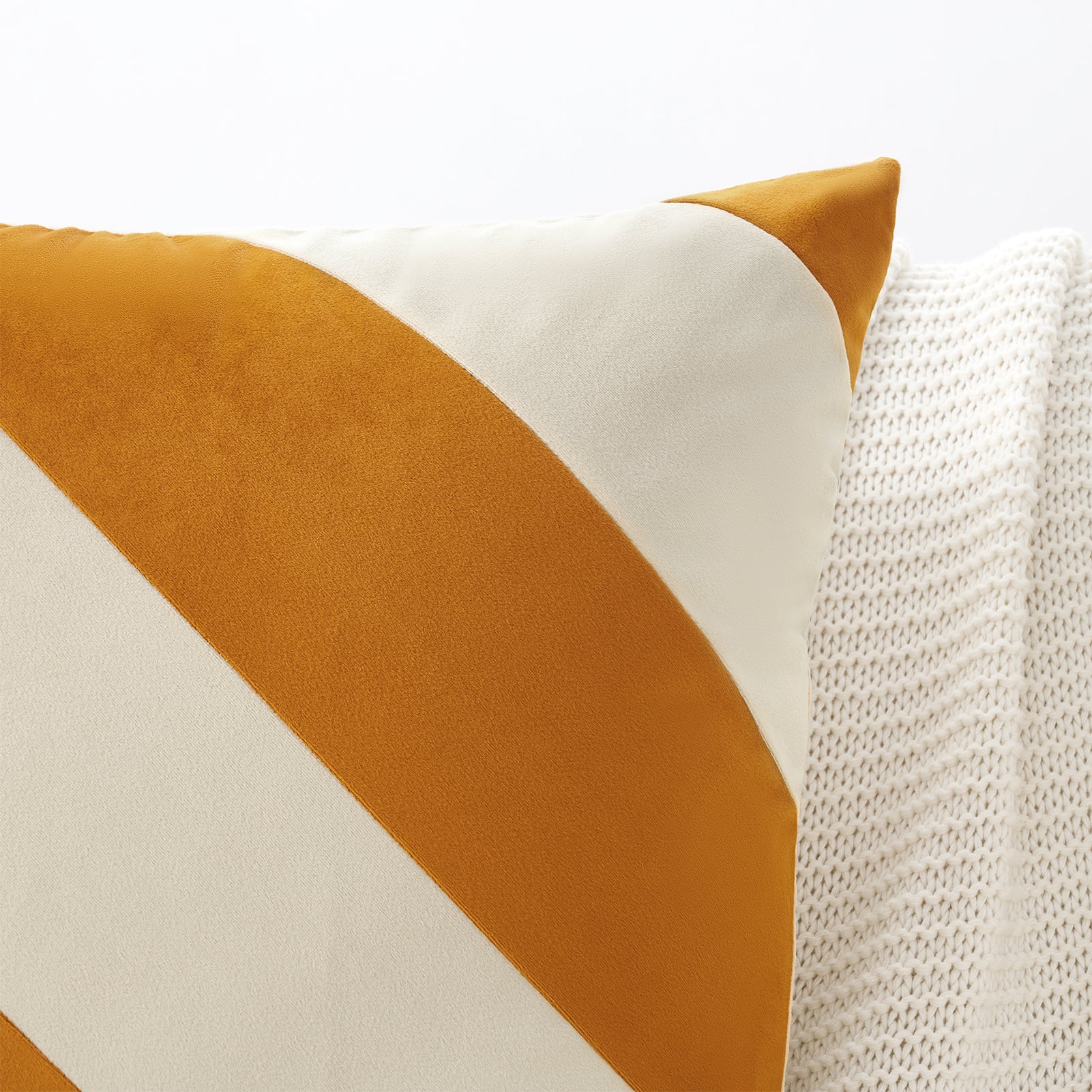 Decorative pillow with orange and white geometric pattern on a textured surface