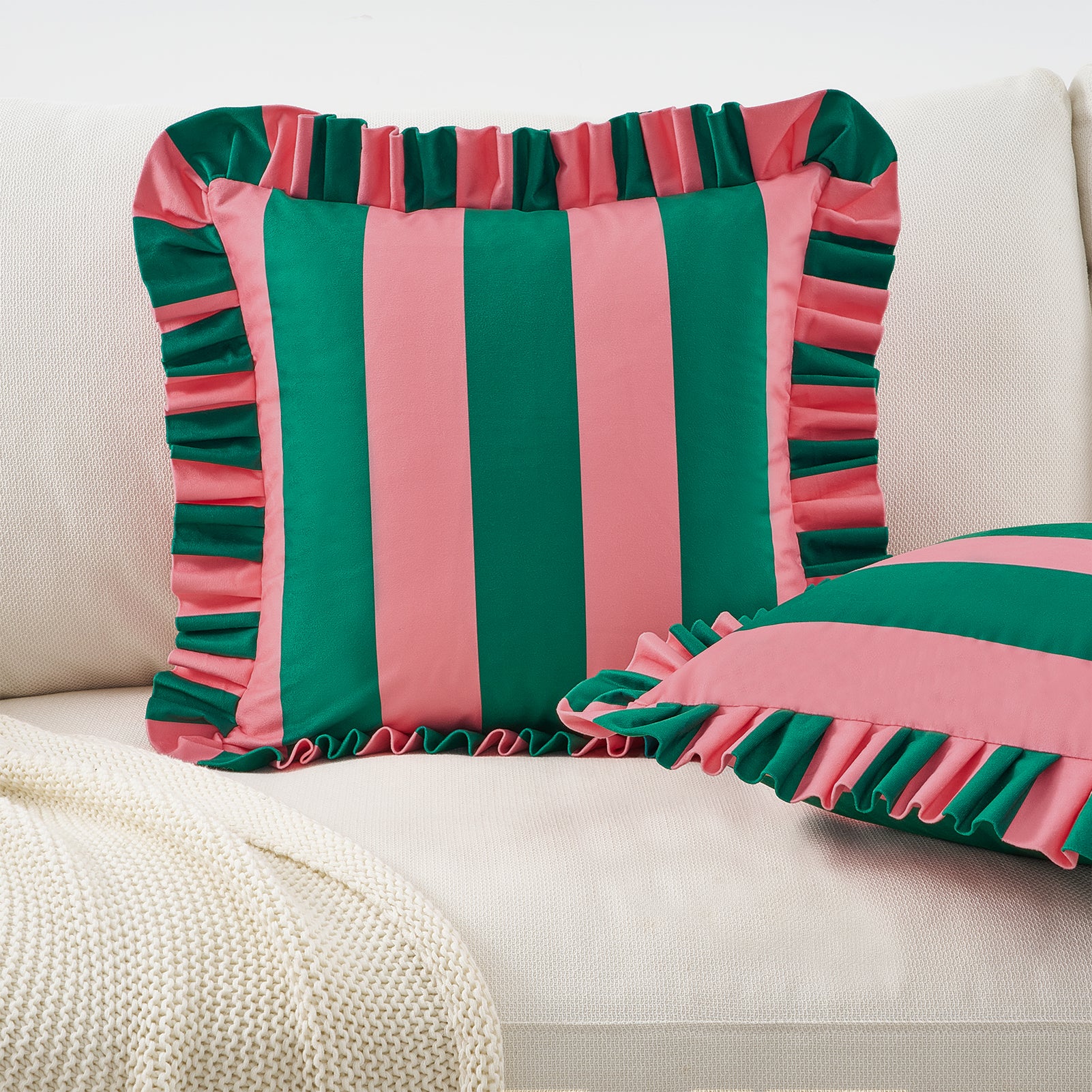 Striped green and pink pillow on a beige sofa