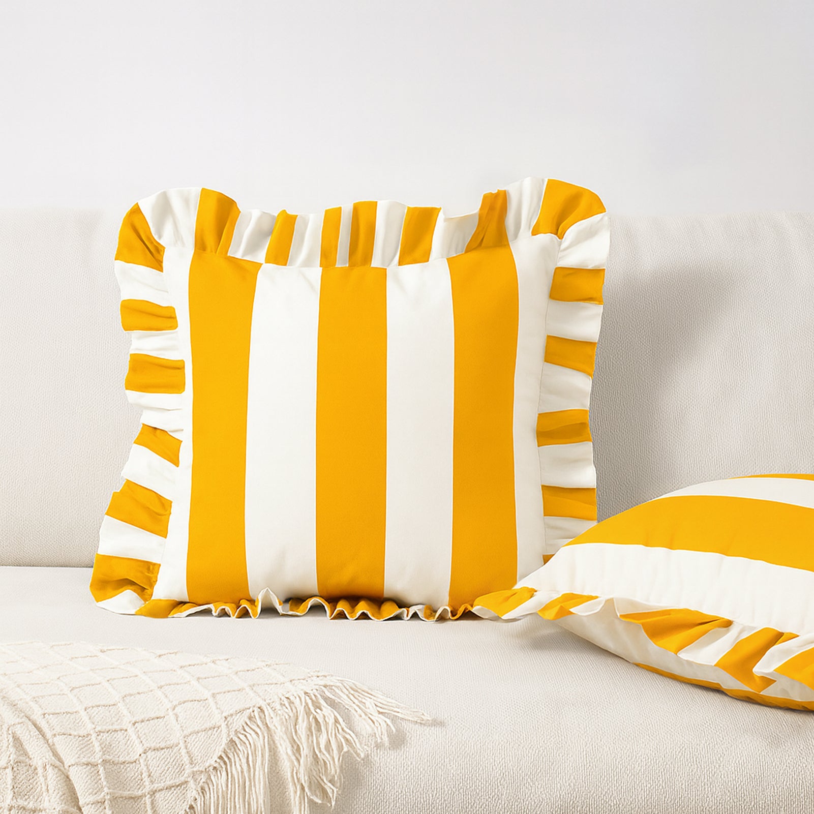 Yellow and white striped pillows on a light-colored sofa.