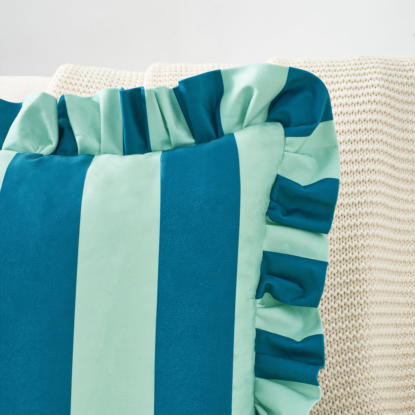 Striped teal and light blue fabric on a textured surface