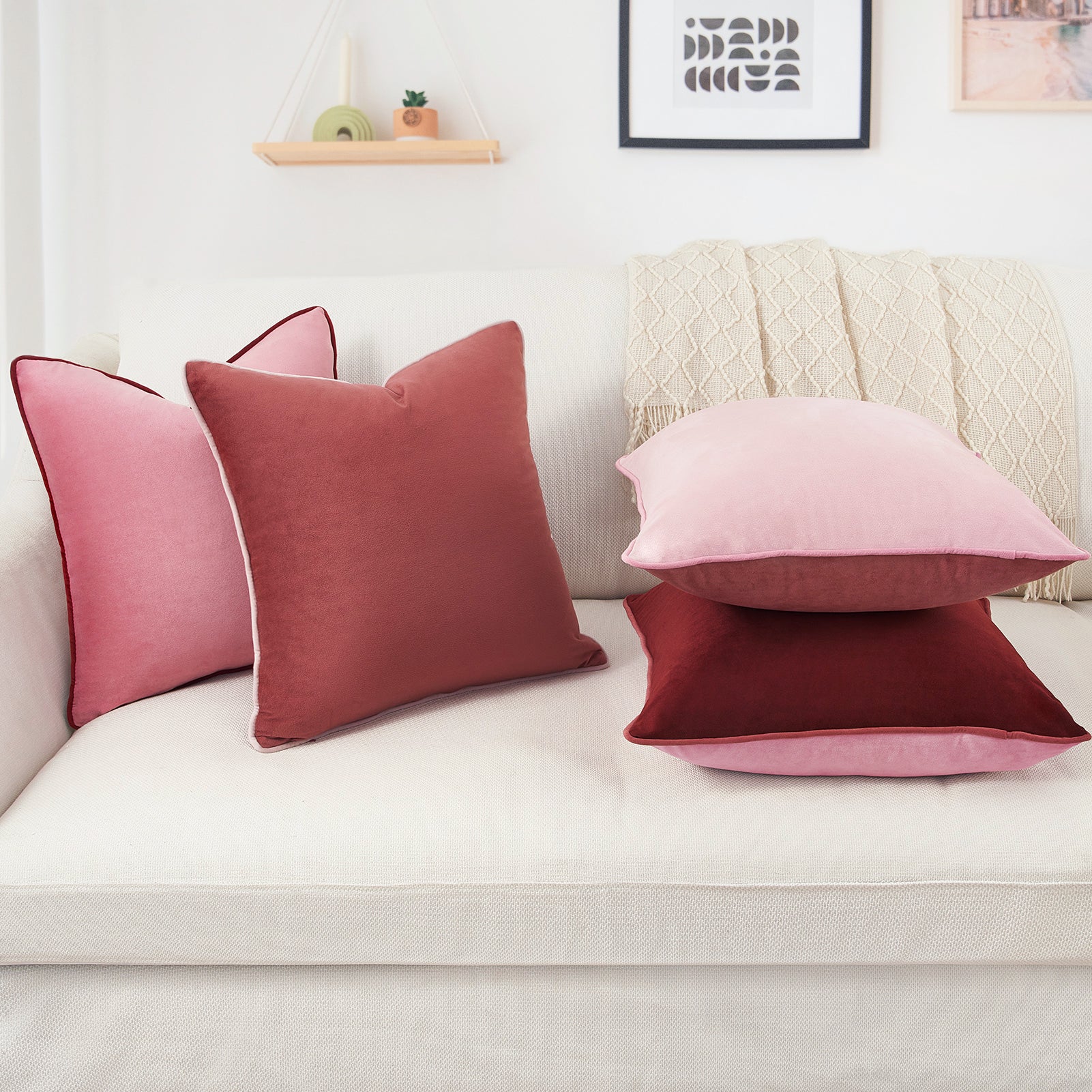 Pink and red cushions on a white sofa with a neutral wall background