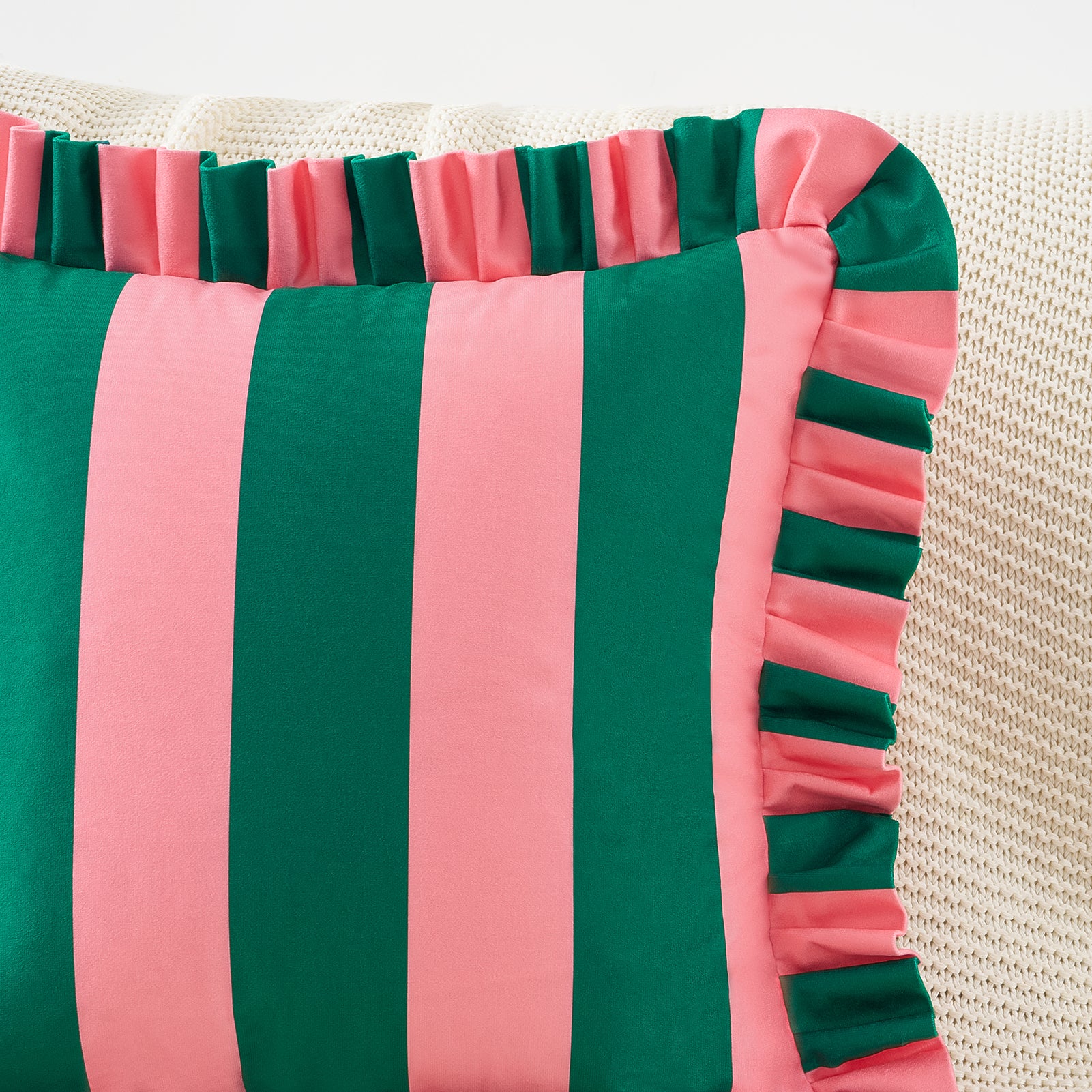 Striped pillow with green and pink colors on a textured background