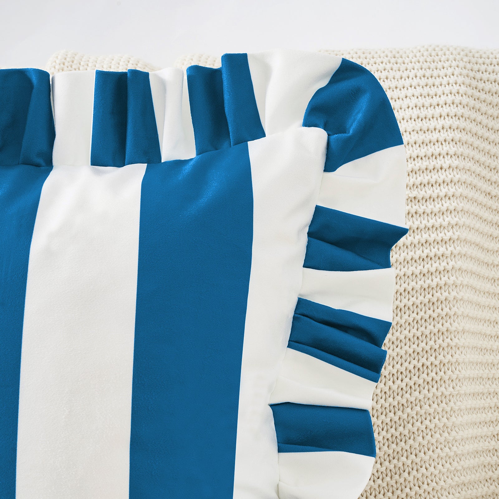 Blue and white striped fabric with ruffled edges on a textured beige background