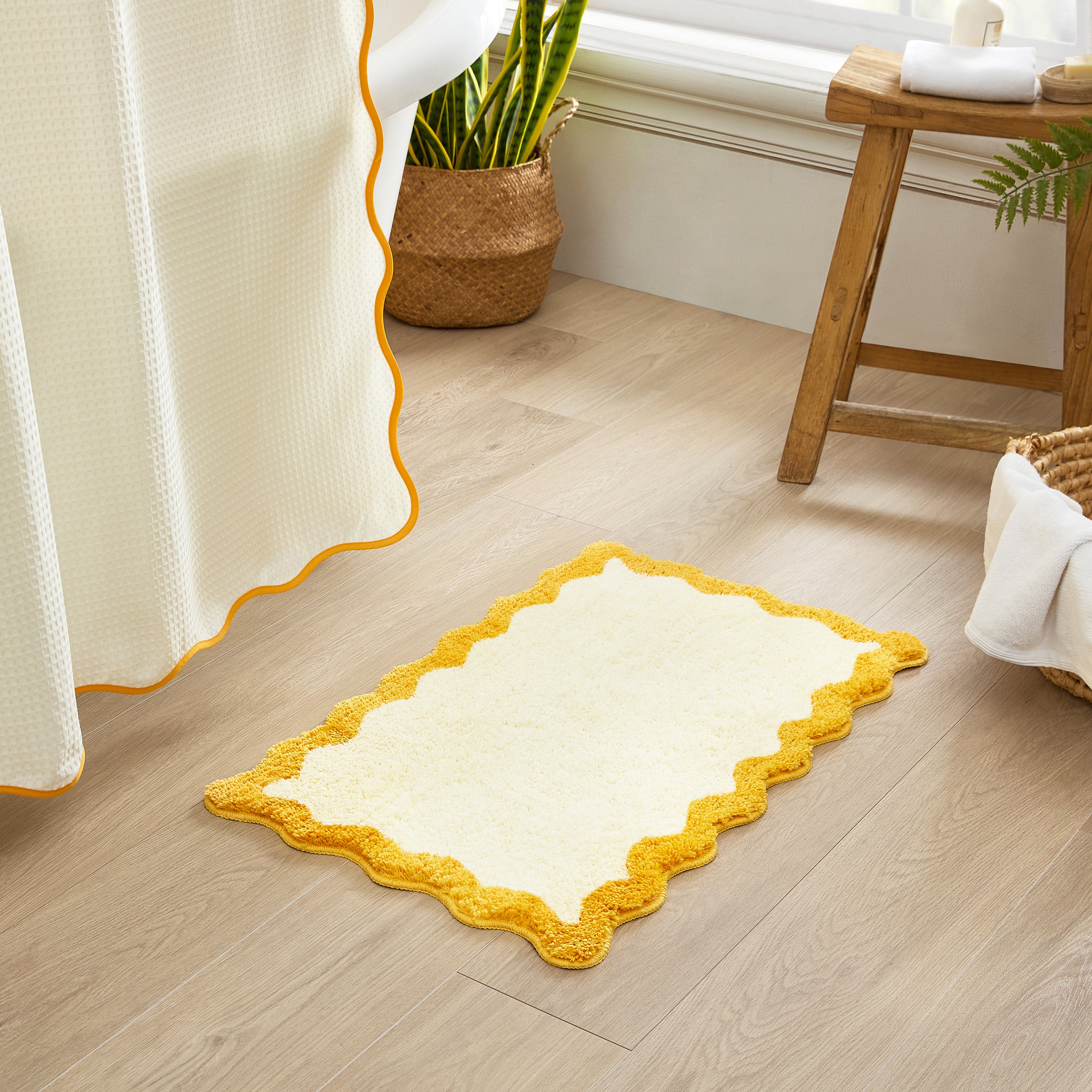 Yellow and white rug on a wooden floor with a plant and stool in the background