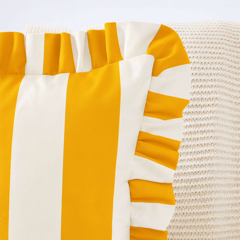 Close-up of a yellow and white striped fabric with ruffled edges on a textured surface.