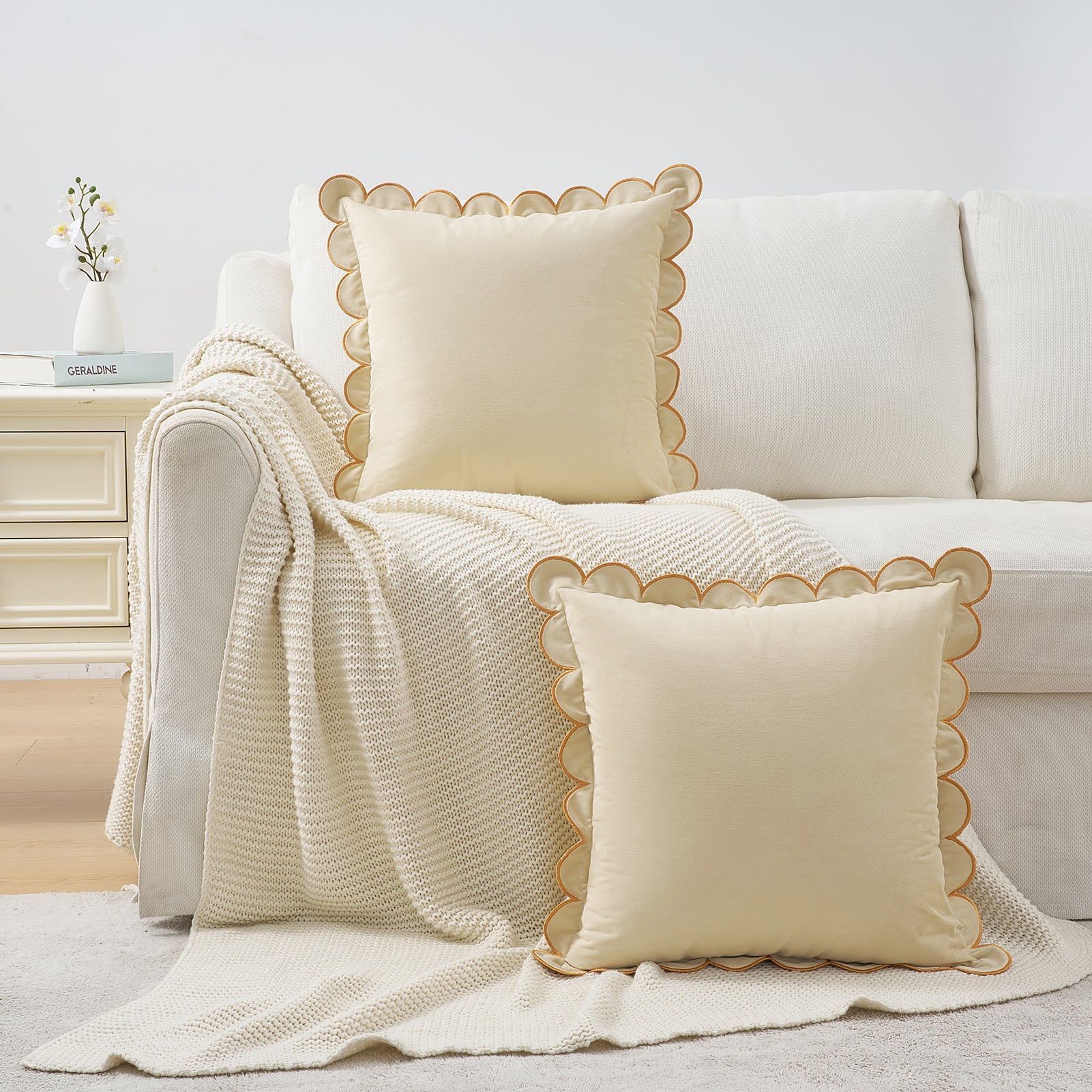 White sofa with decorative pillows and a blanket in a living room setting