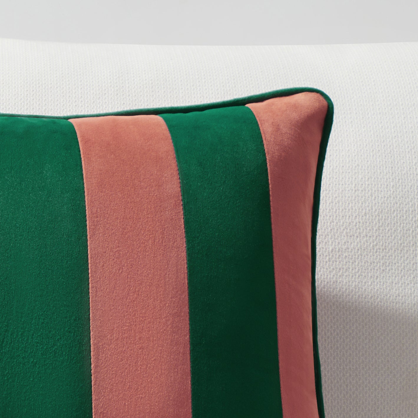 Striped green and pink pillow on a white background
