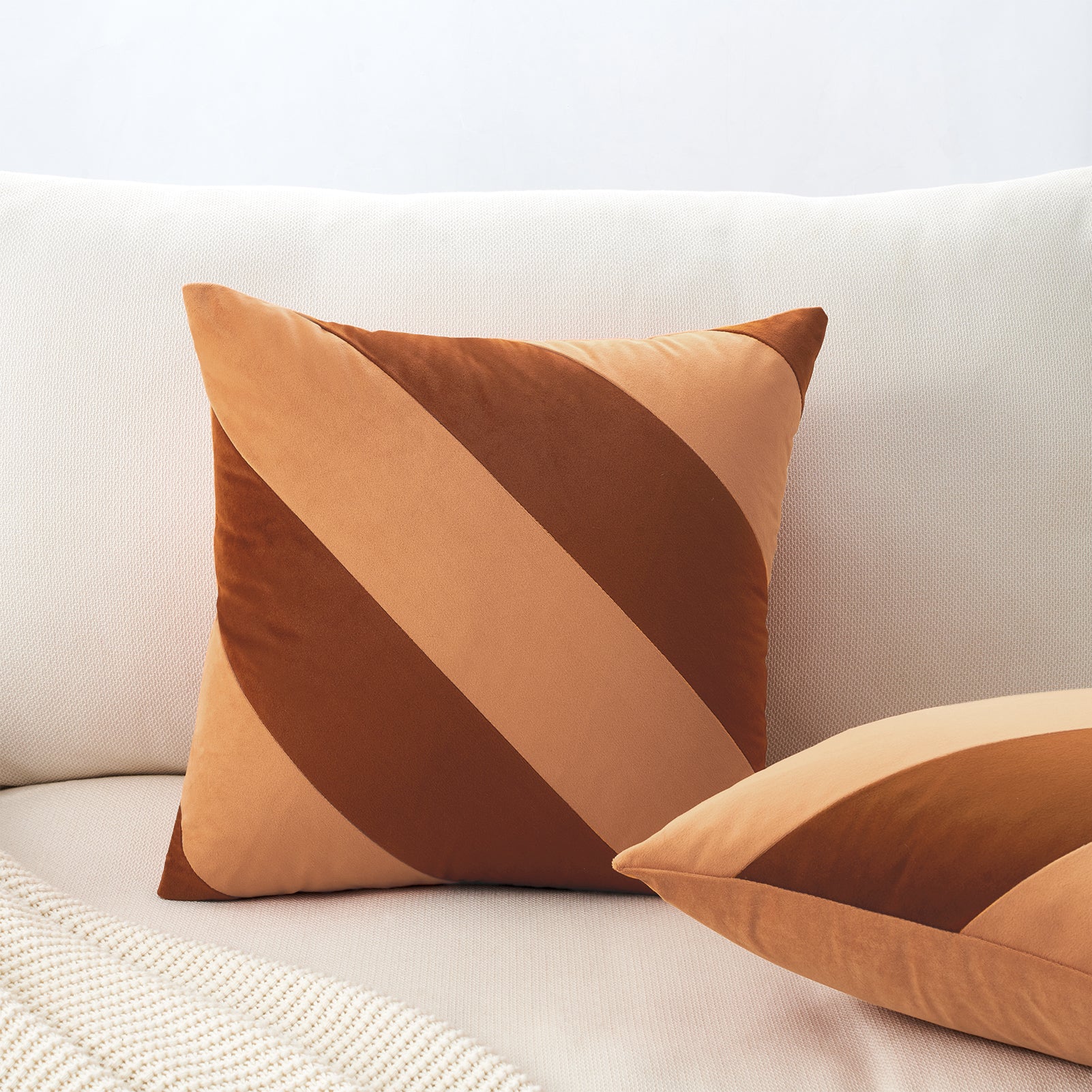 Brown geometric-patterned pillow on a white sofa