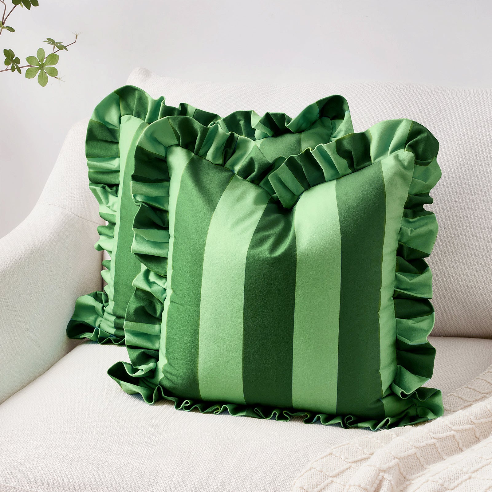Green striped pillow with ruffled edges on a white surface