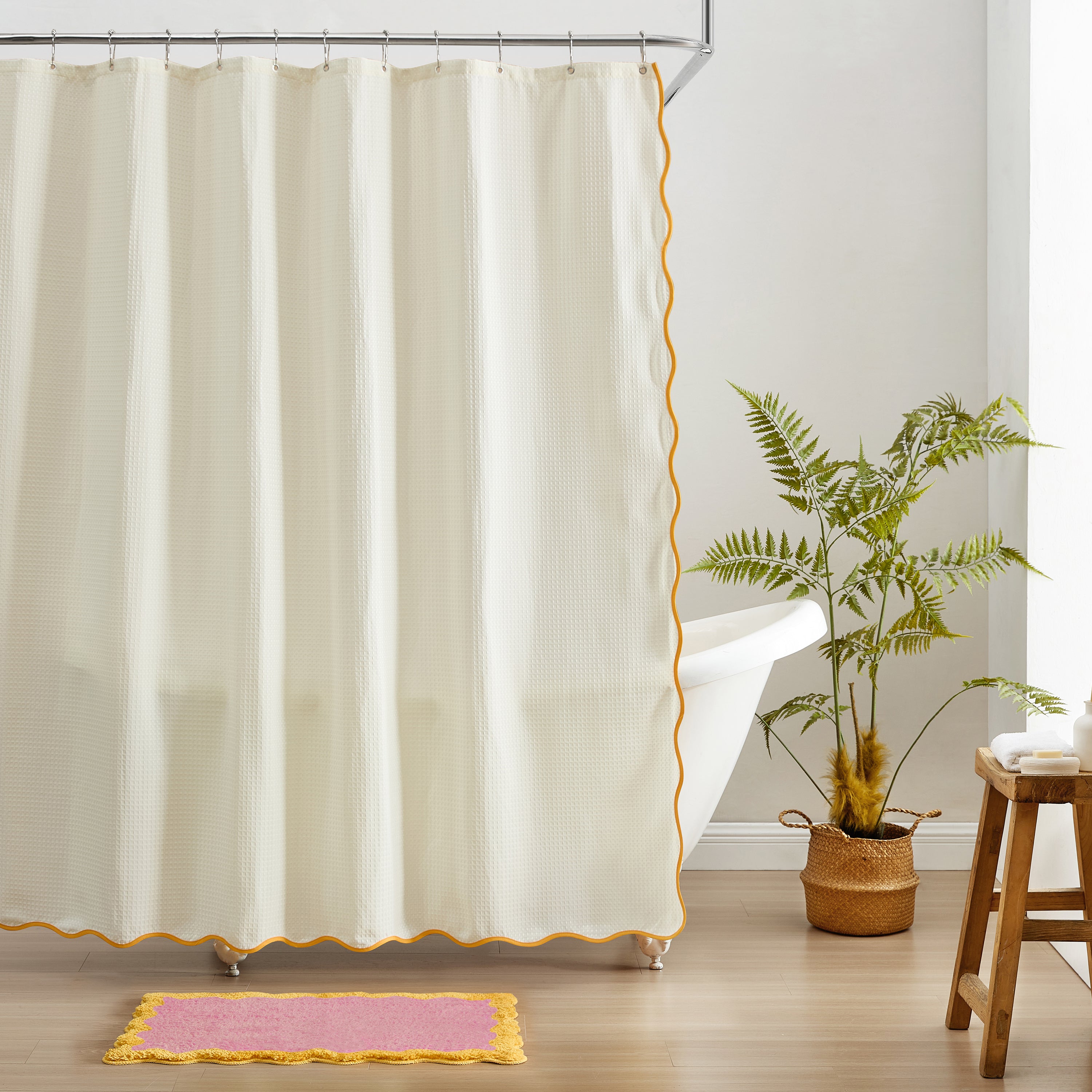 Beige shower curtain with yellow trim in a bathroom setting.