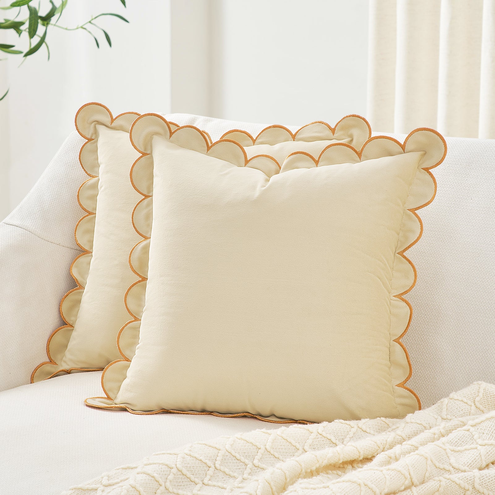 Decorative pillows with scalloped edges on a white sofa