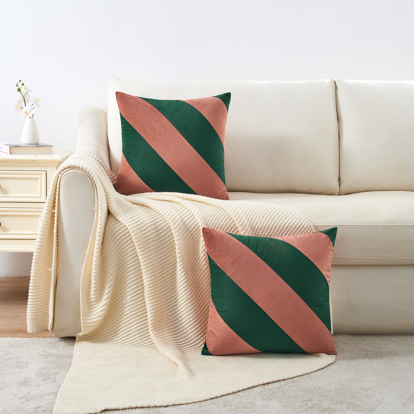 Decorative pillows with green and pink stripes on a beige sofa.