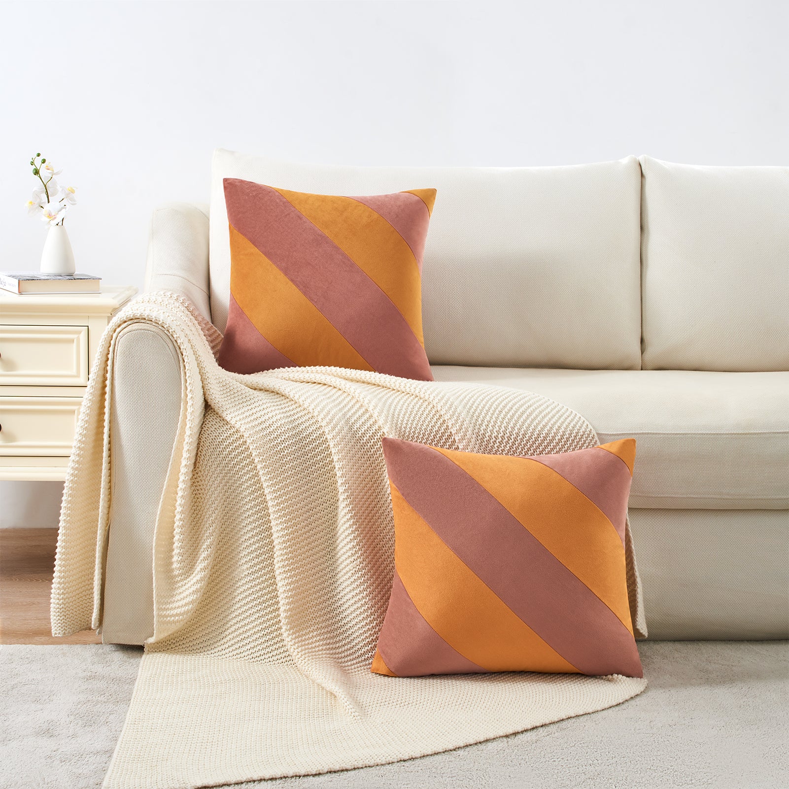 Beige sofa with orange and brown striped cushions in a living room setting.
