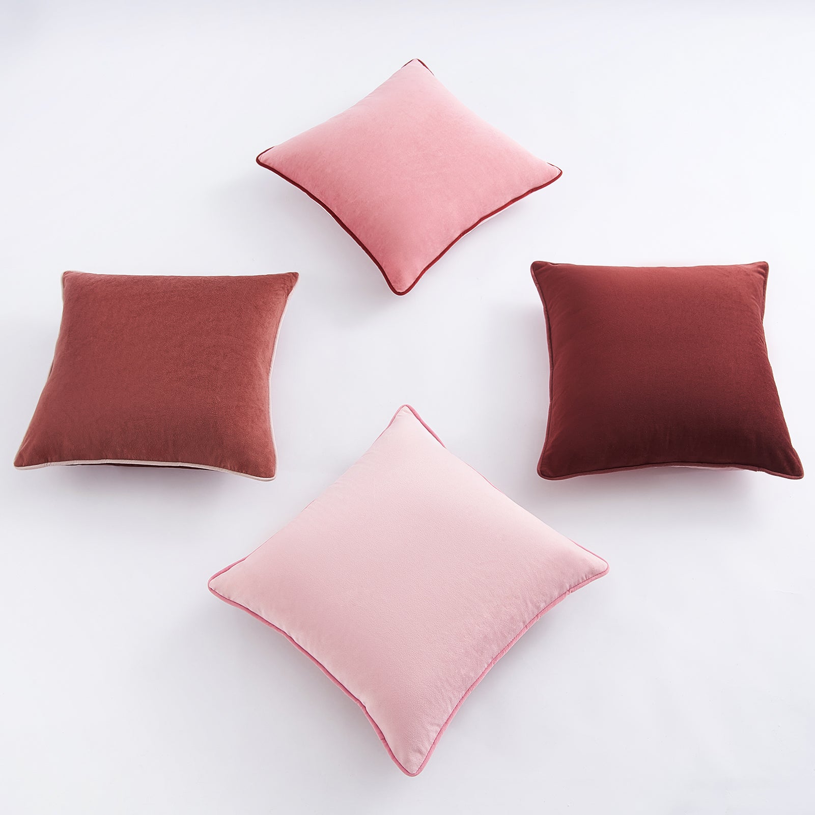 Four cushions in pink and brown on a white background