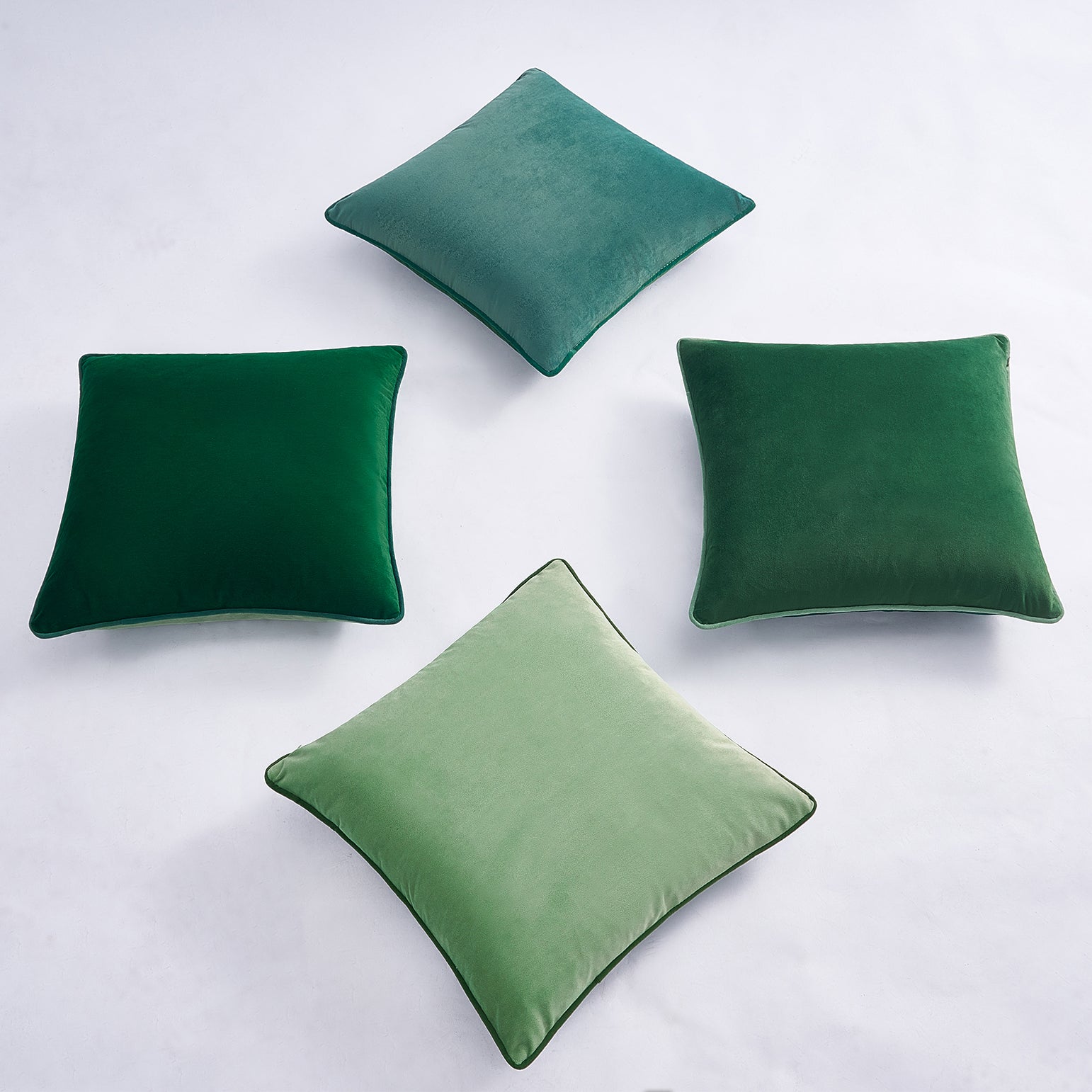 Four green pillows on a white background