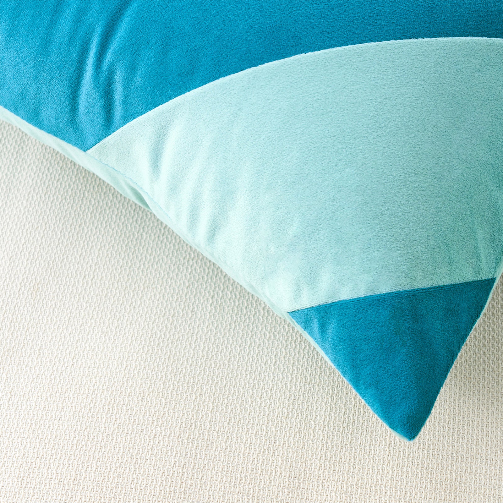 Close-up of a blue and light blue pillow on a white surface
