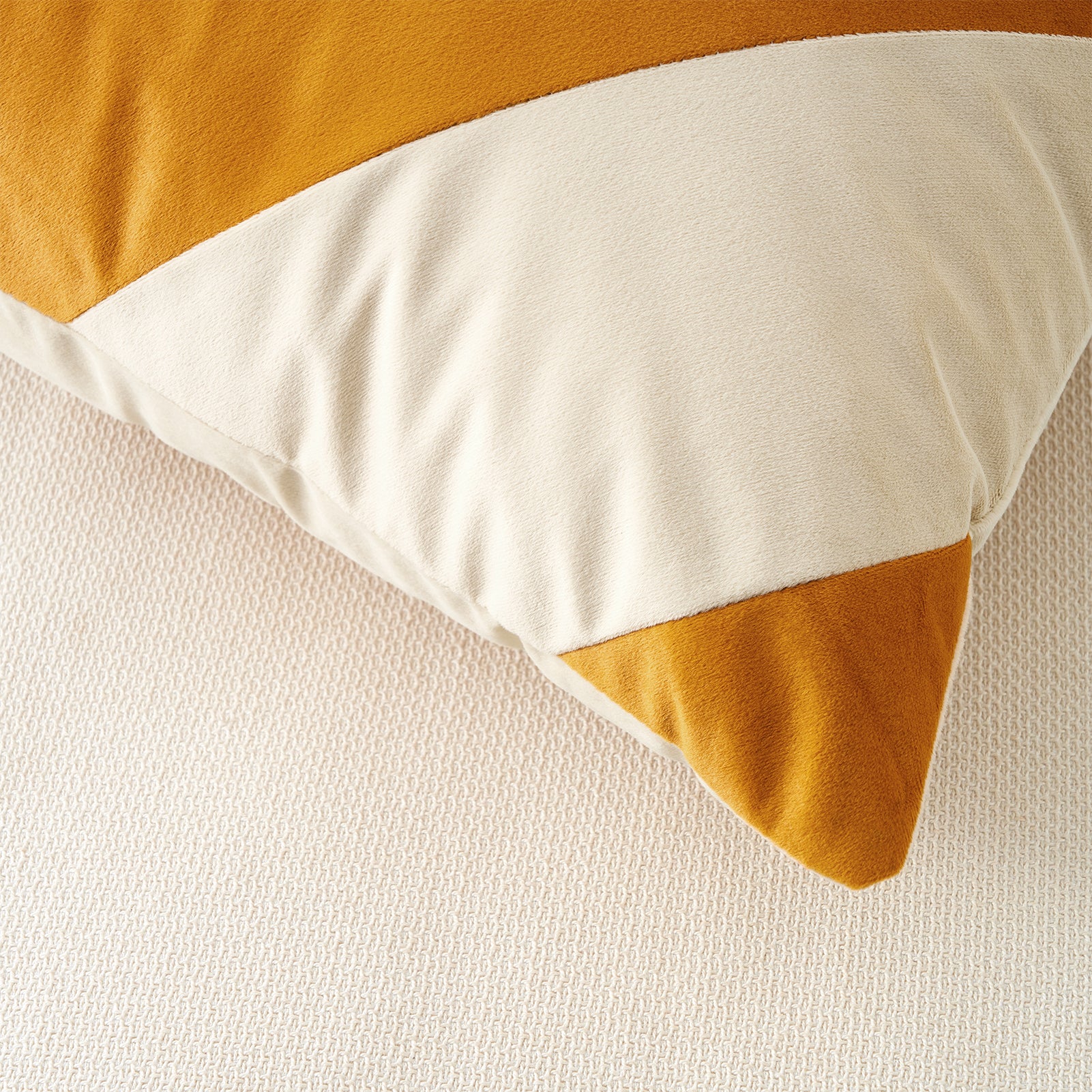 Close-up of a pillow with yellow and white stripes on a beige background