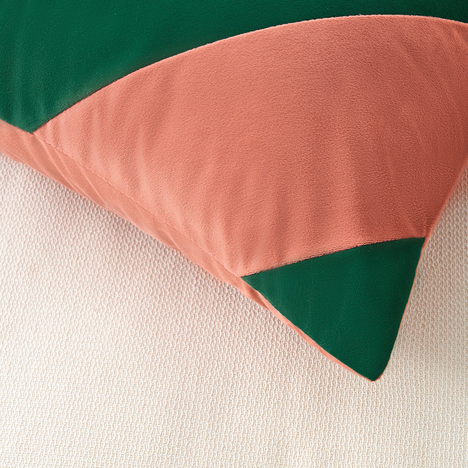 Color-blocked fabric with green, pink, and beige sections on a textured background