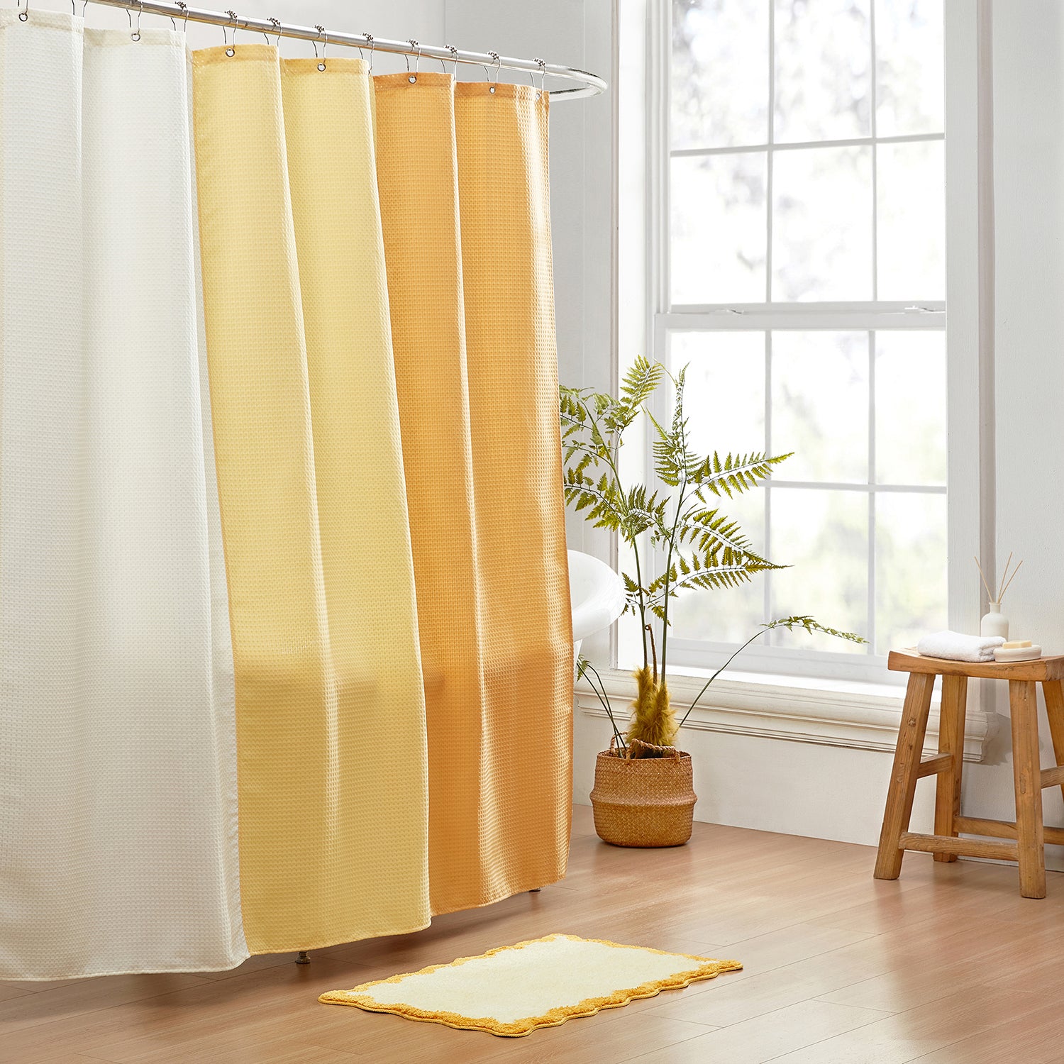 Shower curtain with gradient yellow and orange colors in a bathroom setting.